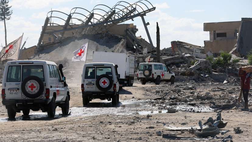 Red Cross vehicles escort a truck transporting the bodies of Palestinians who had been held in Israel during the war, in Khan Younis