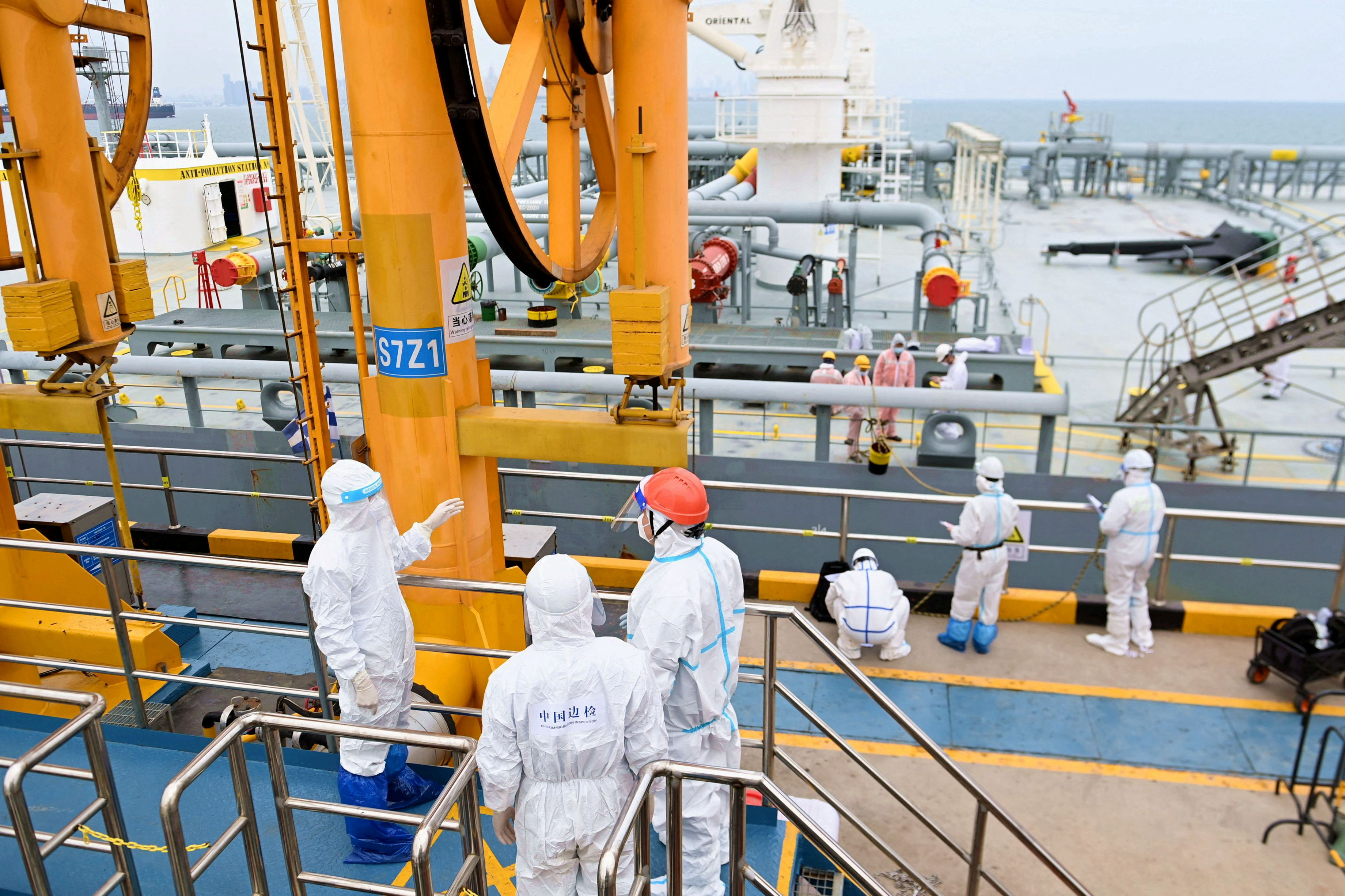 FILE PHOTO: Immigration inspection officers check a tanker carrying imported crude oil at the port in Qingdao