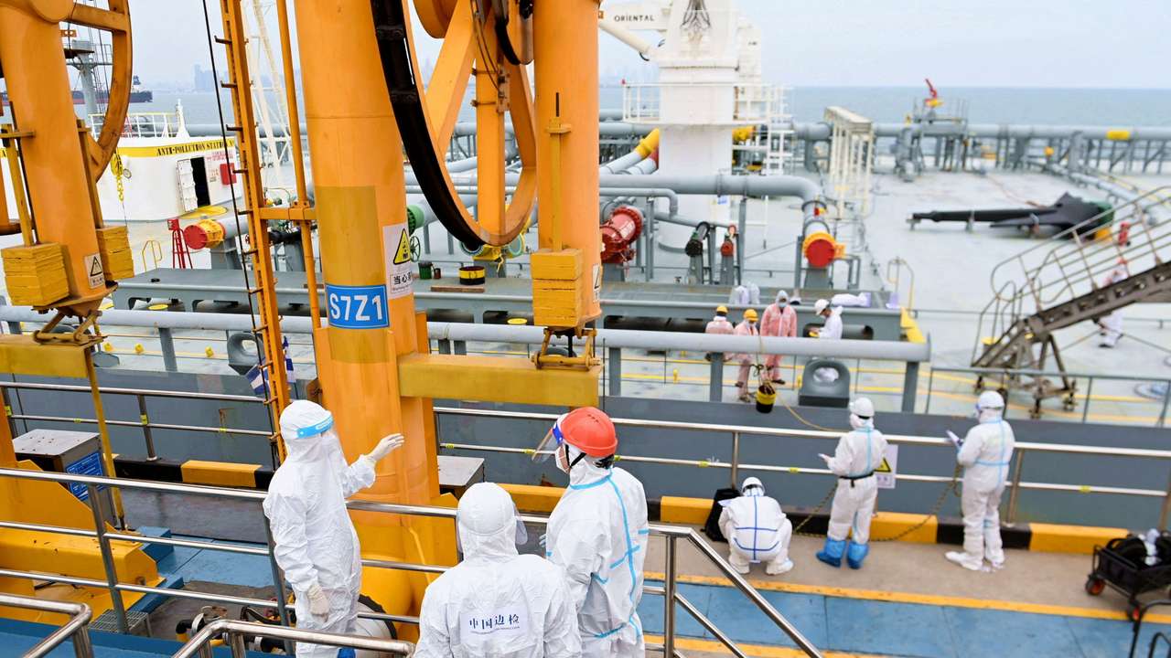 FILE PHOTO: Immigration inspection officers check a tanker carrying imported crude oil at the port in Qingdao