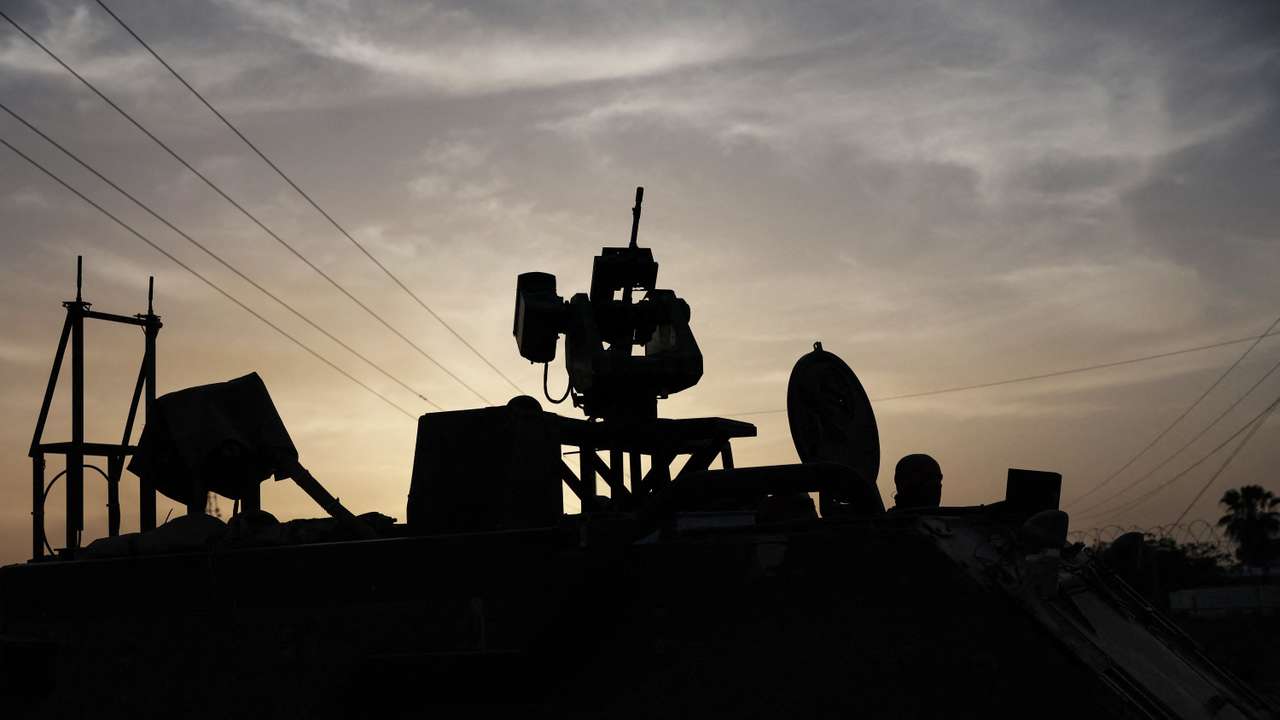 An Israeli solider is seen in silhouette inside an armored personnel carrier, as military operations continue in the southern Gaza city of Rafah, at an area outside Kerem Shalom, Israe