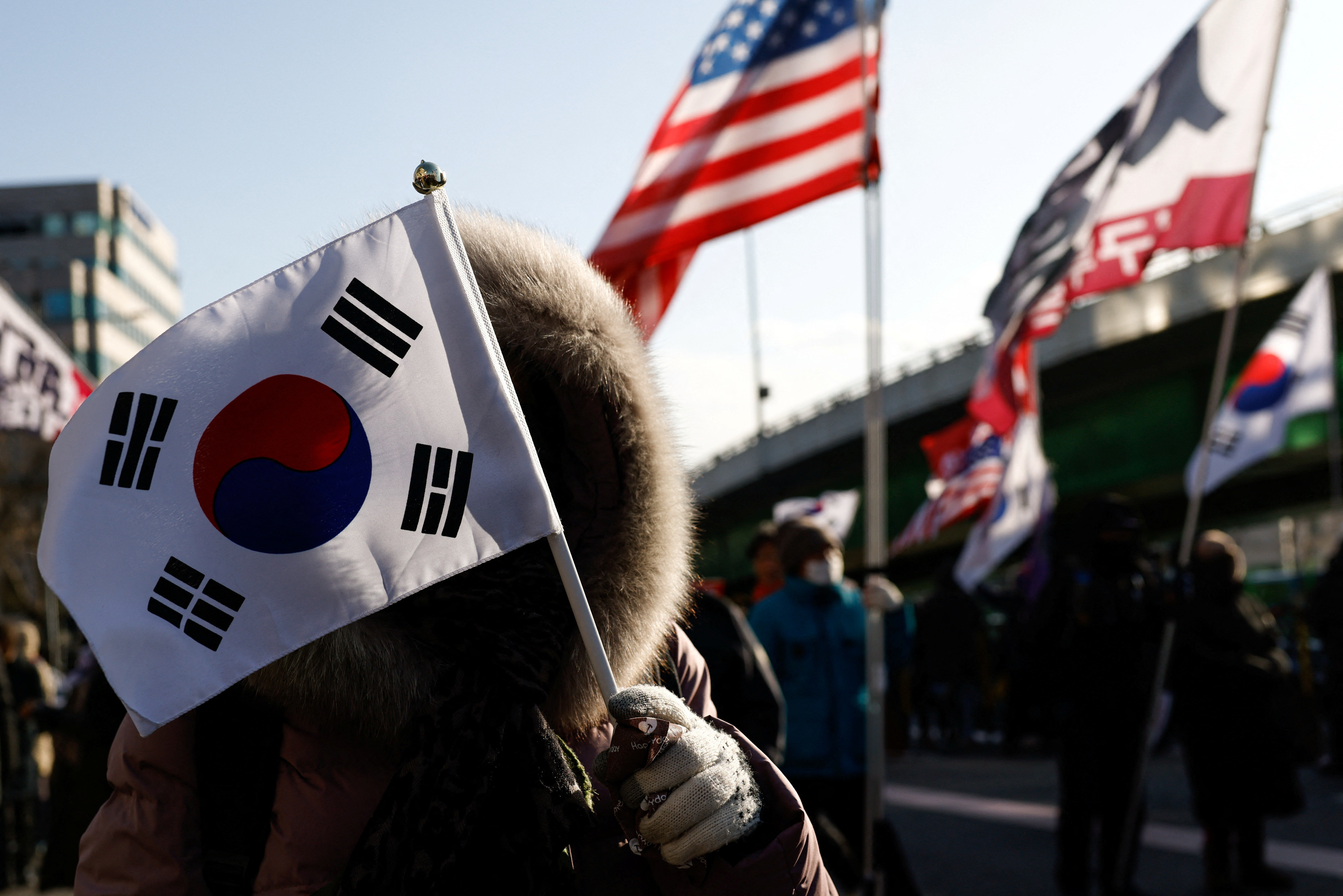 Pro-Yoon demonstrators hold U.S. and Korean flags as they take part in a rally in support of impeached South Korean President Yoon Suk Yeol near his official residence in Seoul