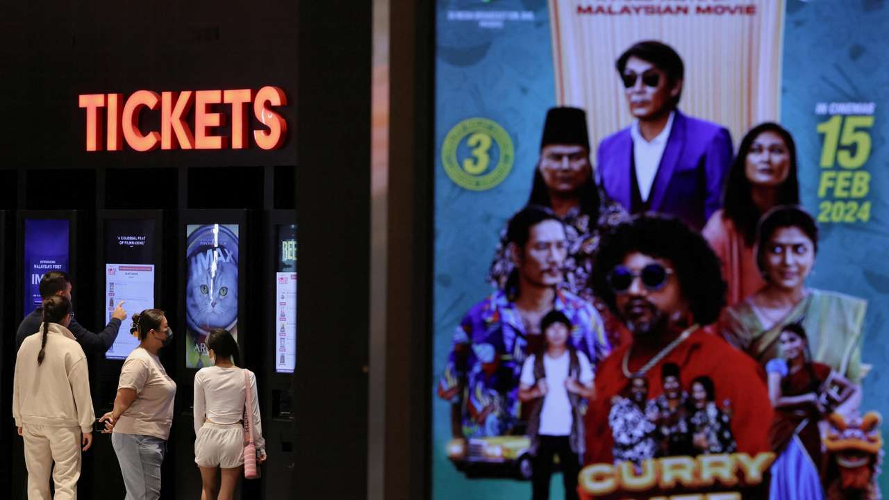 People buy movie tickets from a movie ticket kiosk at a cinema in Kuala Lumpur