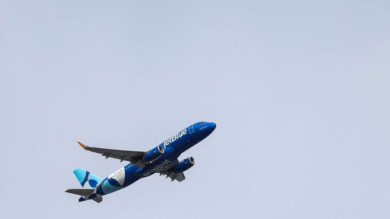 A JetBlue Airlines plane flies over Queens, New York City
