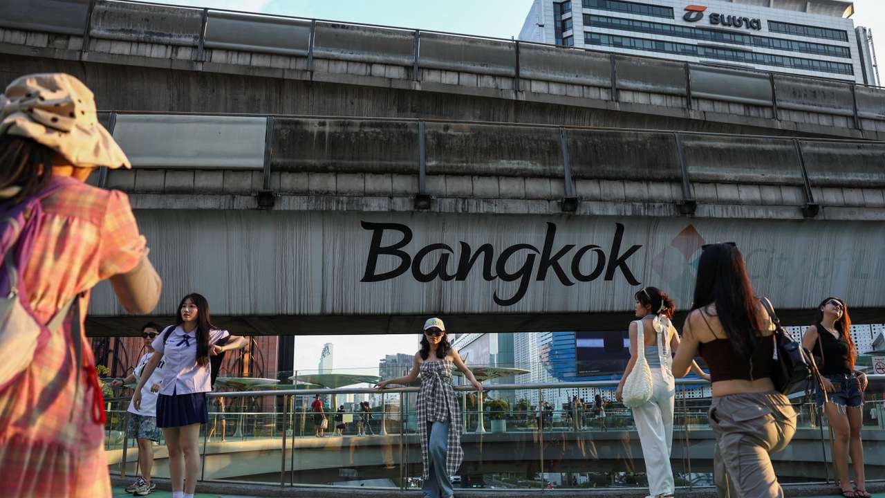 Chinese tourists take pictures in downtown as temperatures reached 39 degrees Celsius (102.2 Fahrenheit) in Bangkok