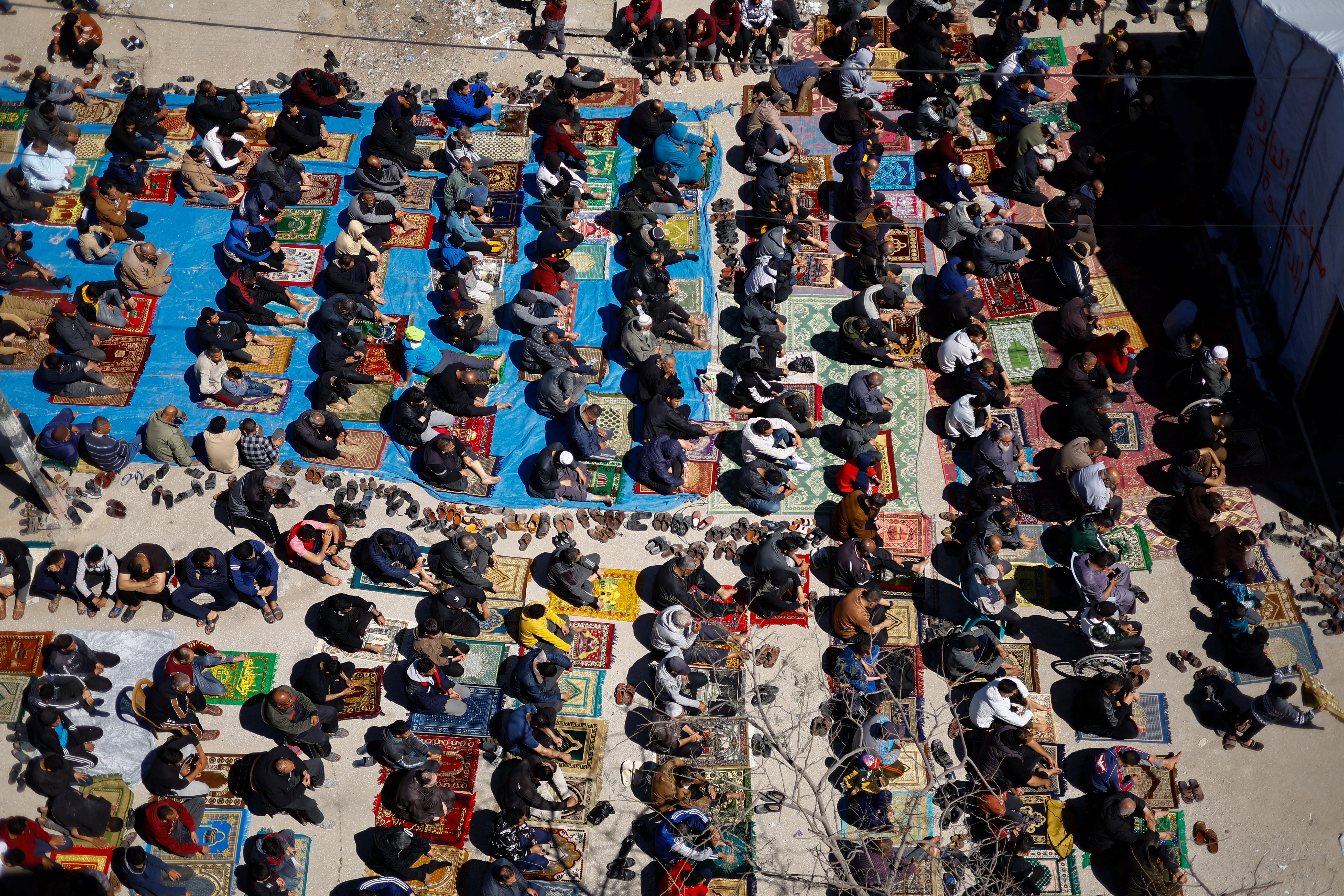 Palestinians perform first Friday prayers during Ramadan near the ruins of a destroyed mosquein, in Rafah