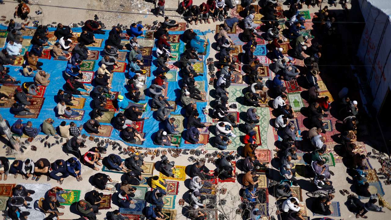 Palestinians perform first Friday prayers during Ramadan near the ruins of a destroyed mosquein, in Rafah