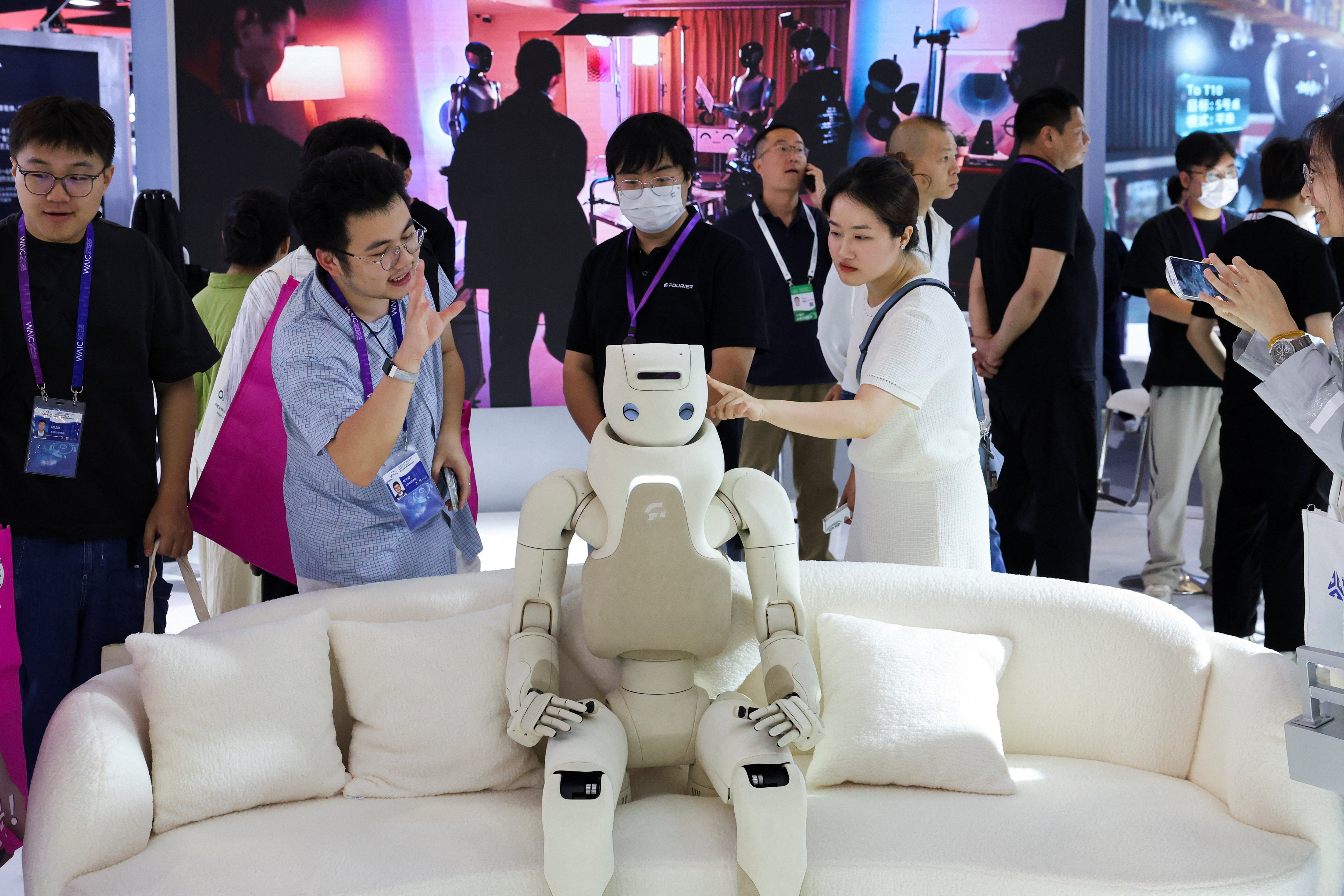 People interact with a humanoid robot at Fourier booth during WAIC in Shanghai