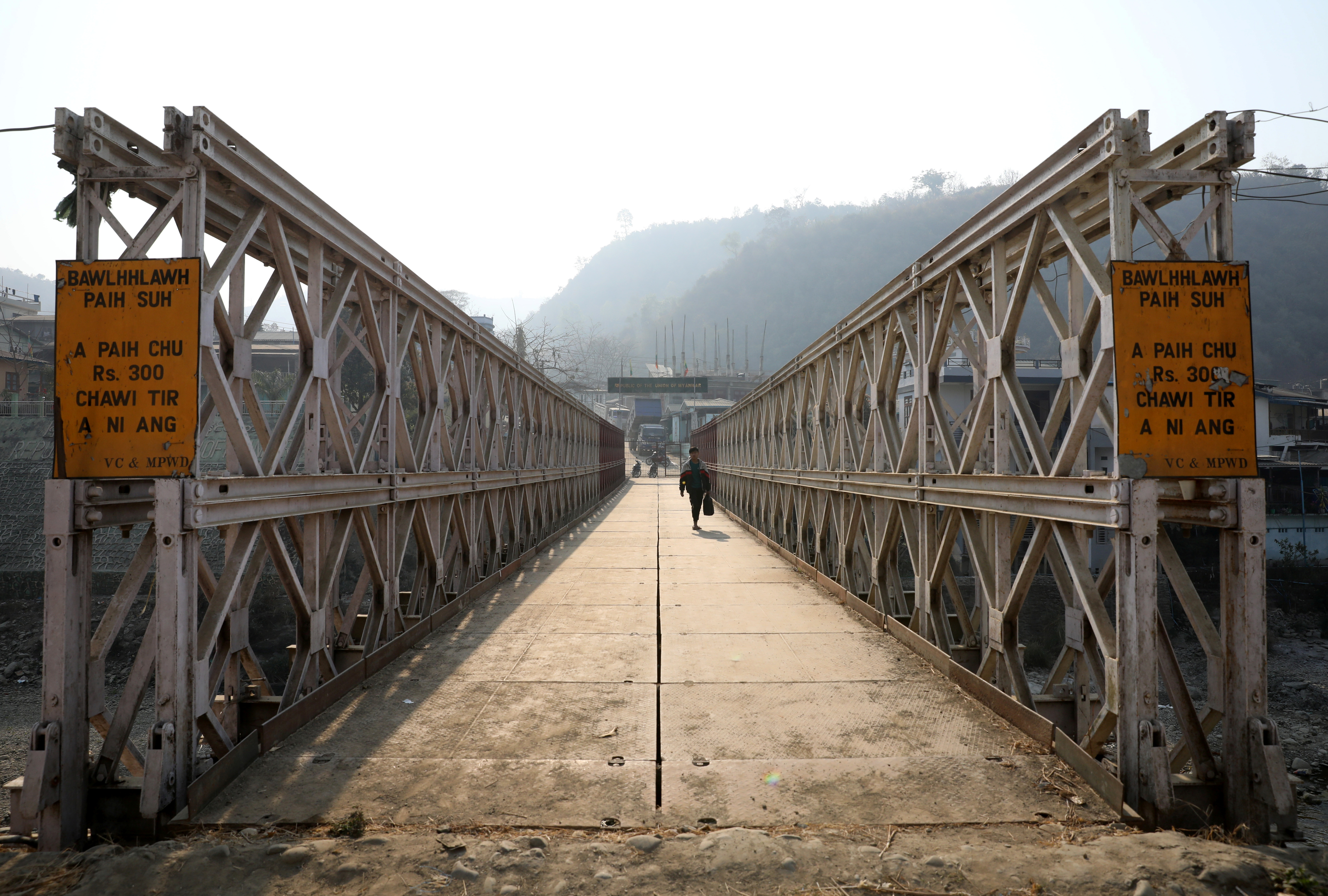 FILE PHOTO: A person walks on a bridge that connects Myanmar and India at the border village of Zokhawthar