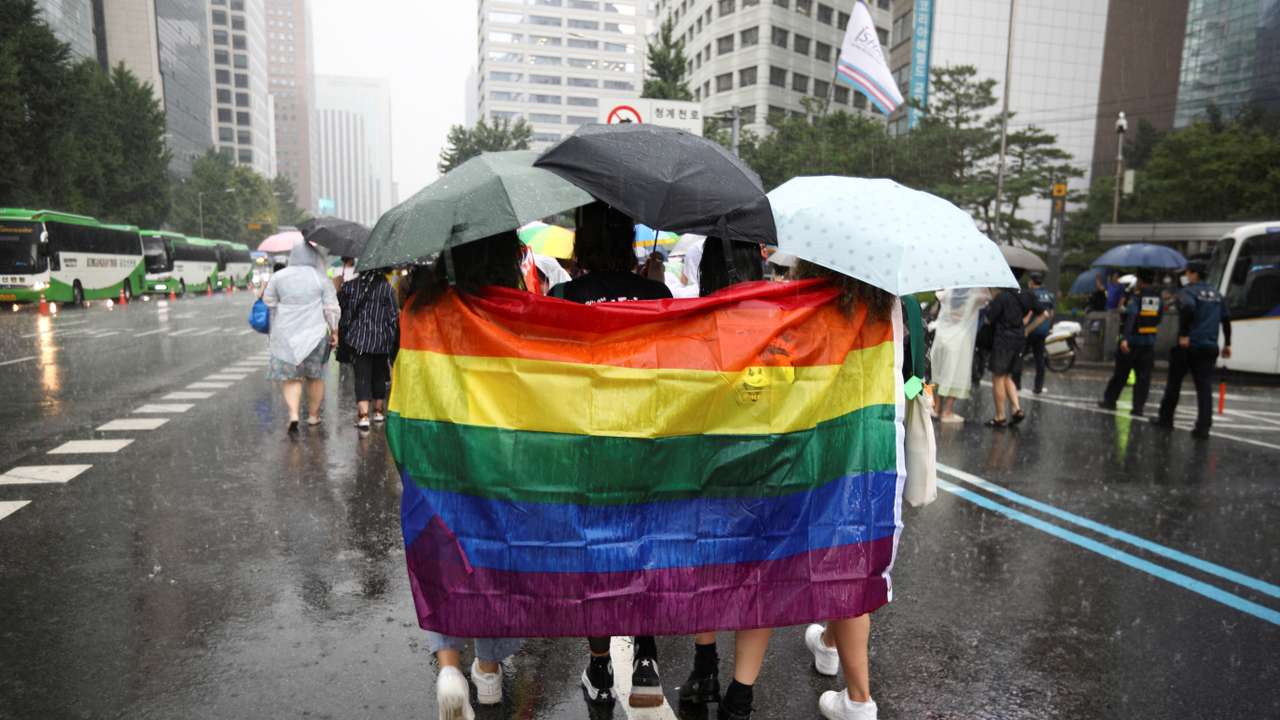 Participants wave a rainbow flag as they march on a street during the Korea Queer Culture Festival 2022 in central Seoul