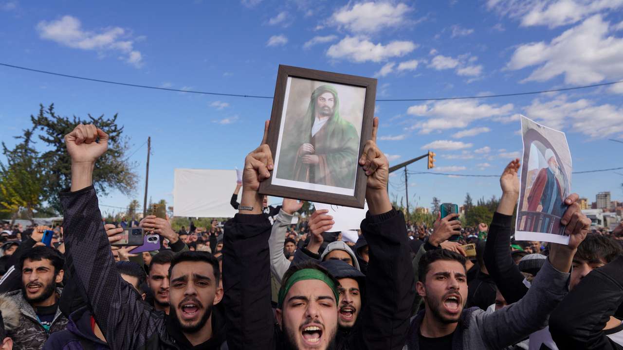 People from the Alawite sect protest as they demand federalism and an end to the killing and violations against Alawites, in Latakia