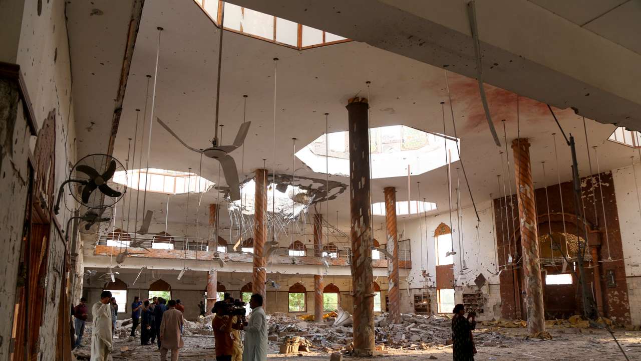 Members of the media film the inside of a building after it was hit by an Indian strike, in Bahawalpur