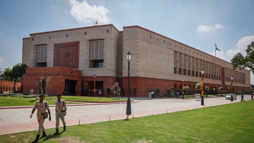 Police officers walk in front of India's new parliament building a day before its inauguration in New Delhi