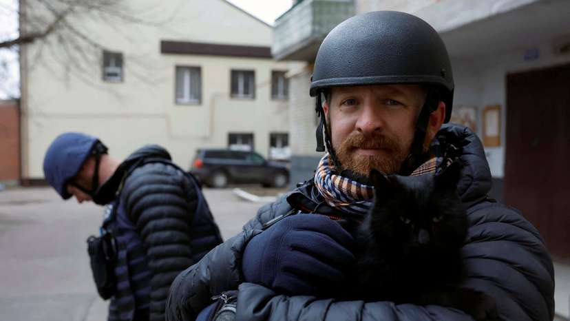 Reuters safety advisor Ryan Evans holds a cat during a news assignment, in Kramatorsk