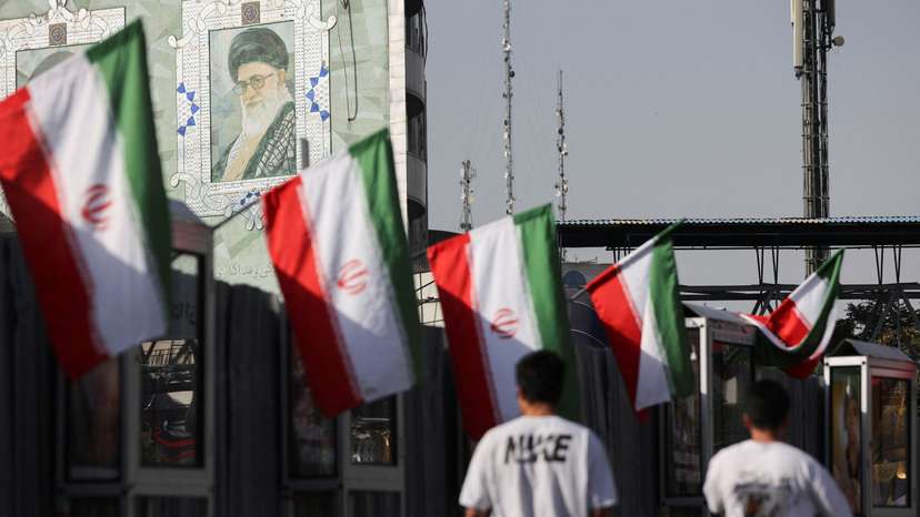 People walk near a mural of Iran's Supreme Leader, Ayatollah Ali Khamenei, in Tehran