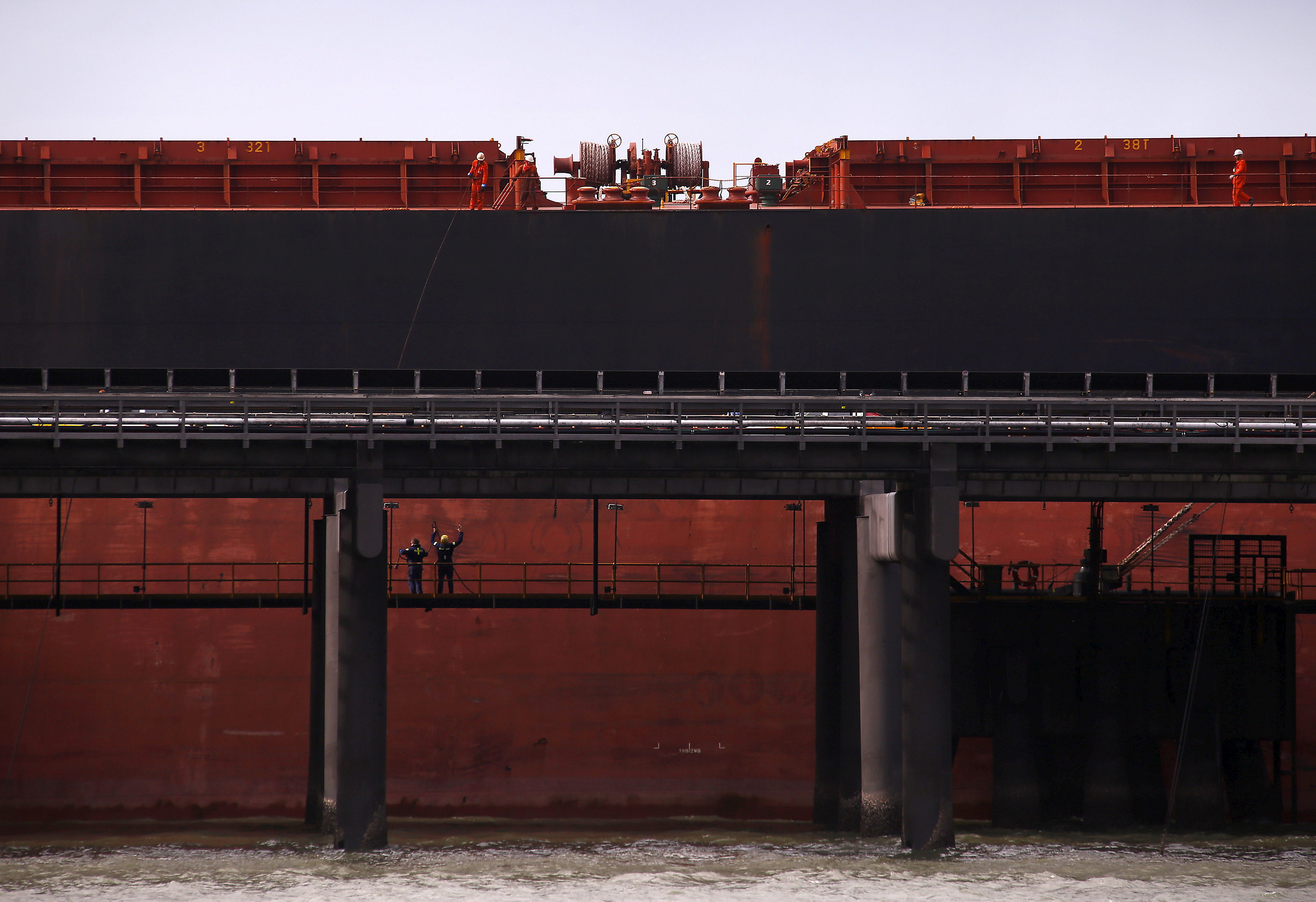 Port workers load a ship with coal at the RG Tanna Coal Terminal