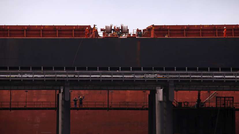 Port workers load a ship with coal at the RG Tanna Coal Terminal