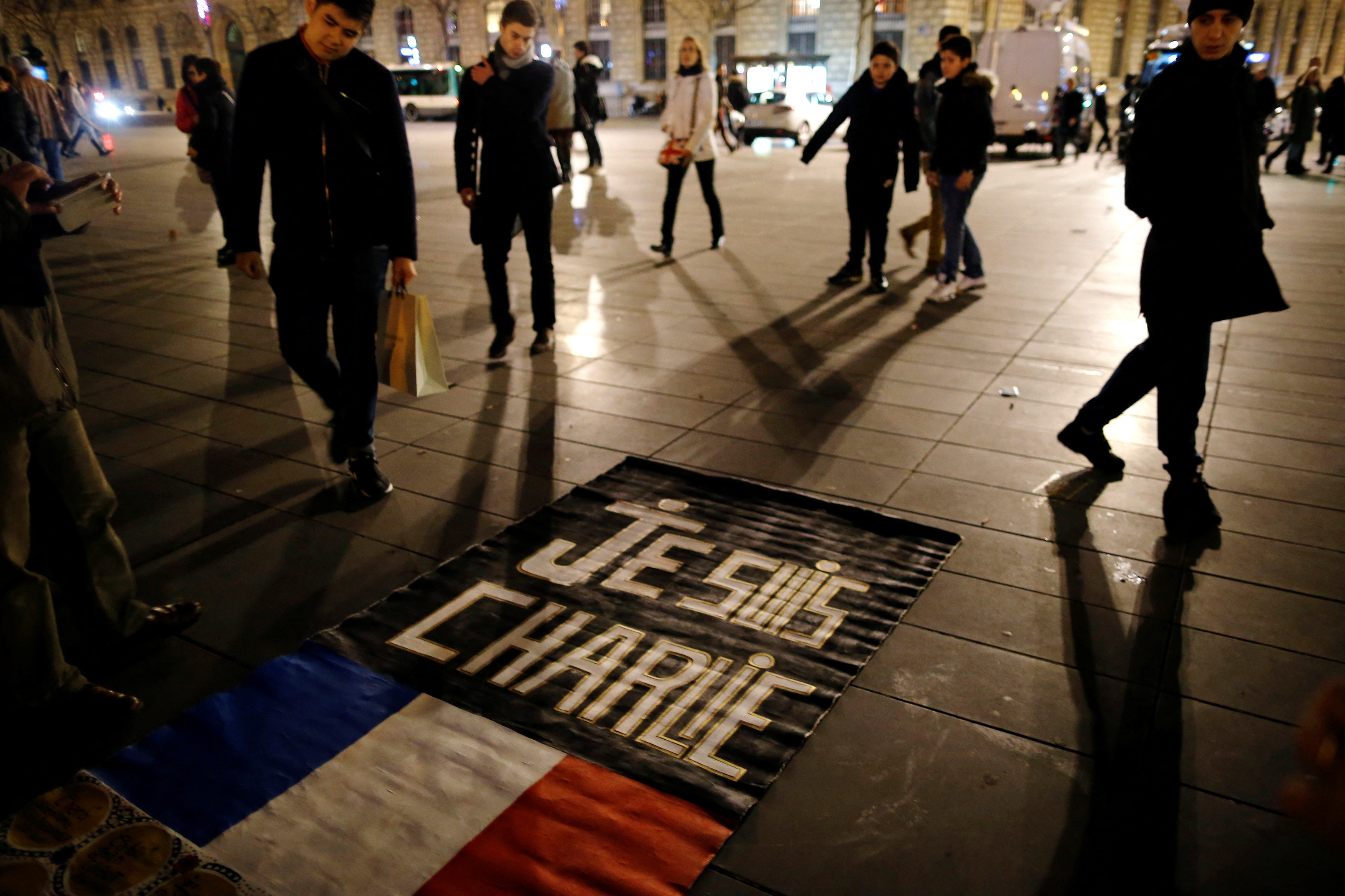 FILE PHOTO: People gather on the Place de la Republique square to pay tribute to the victims of last year's shooting at the French satirical newspaper Charlie Hebdo in Paris