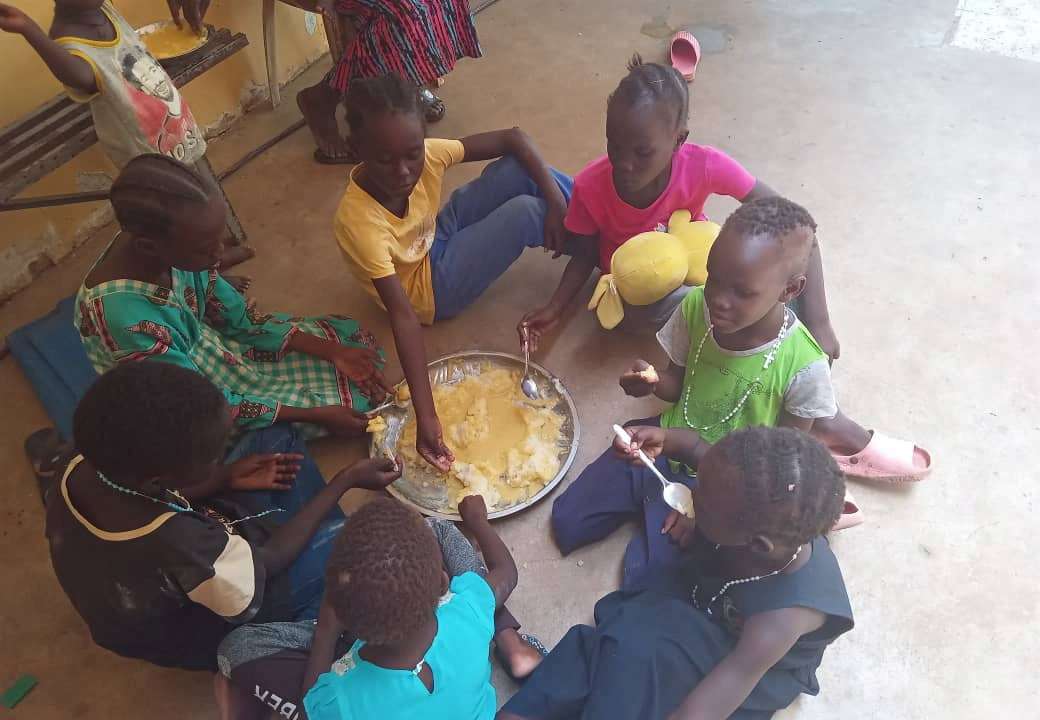 Refugees eat food at "Dar Mariam" a Catholic church and school compound in al-Shajara district, where they took shelter, in Khartoum