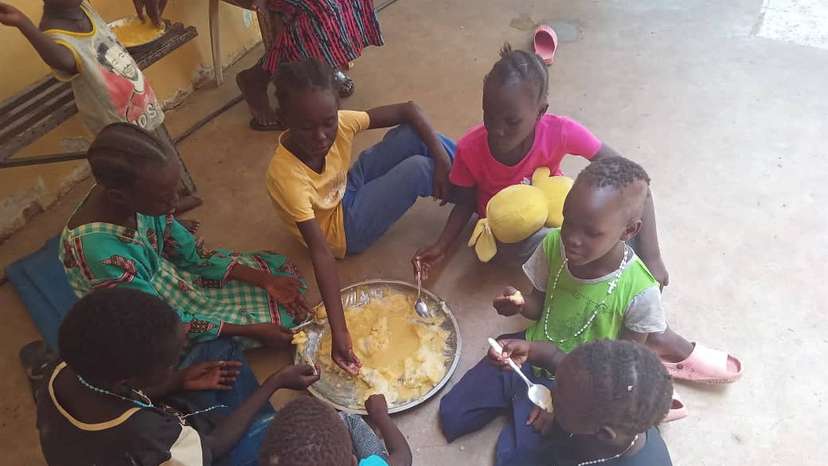 Refugees eat food at "Dar Mariam" a Catholic church and school compound in al-Shajara district, where they took shelter, in Khartoum