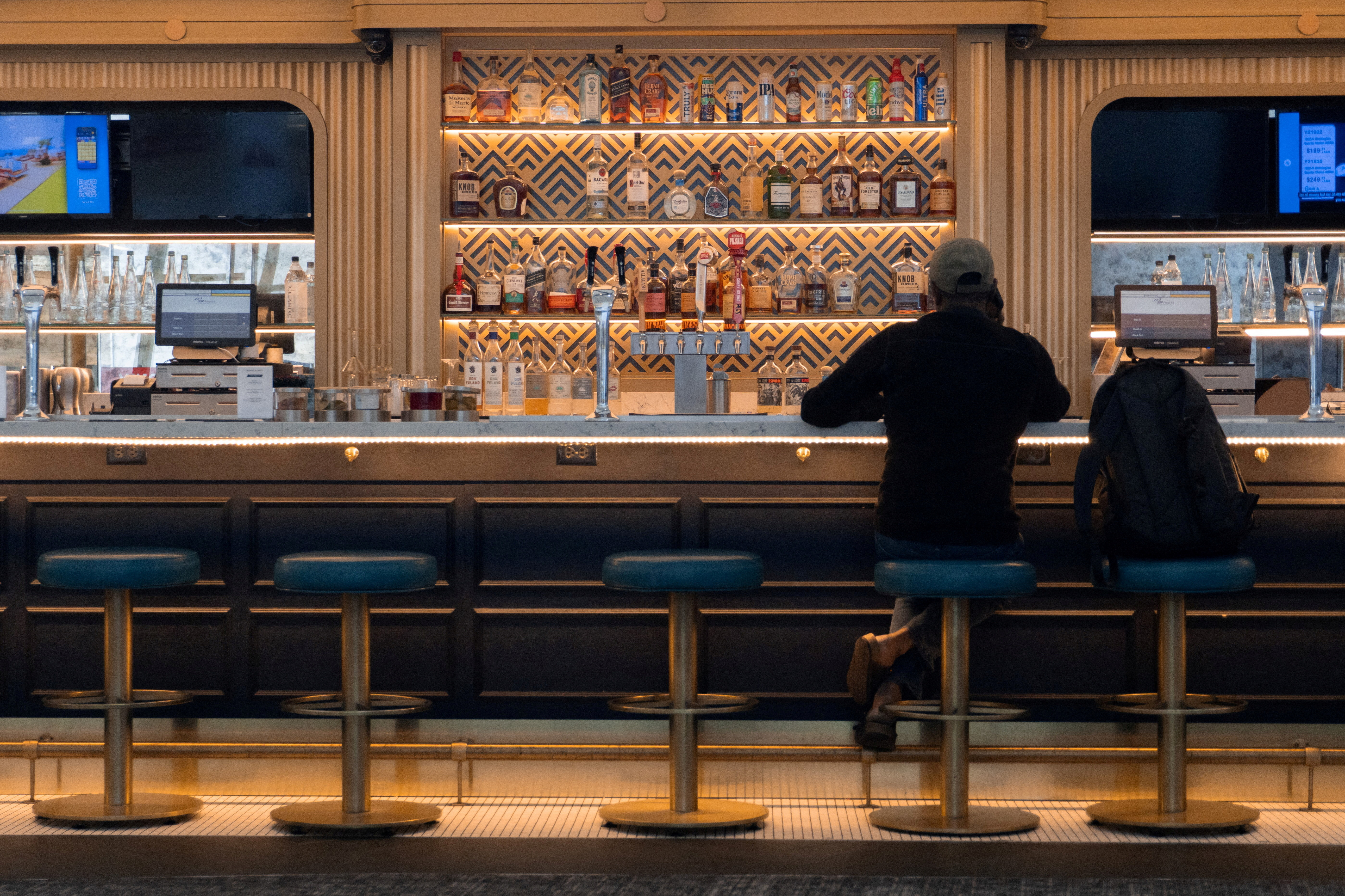FILE PHOTO: A man sits at a bar in LaGuardia Airport in New York