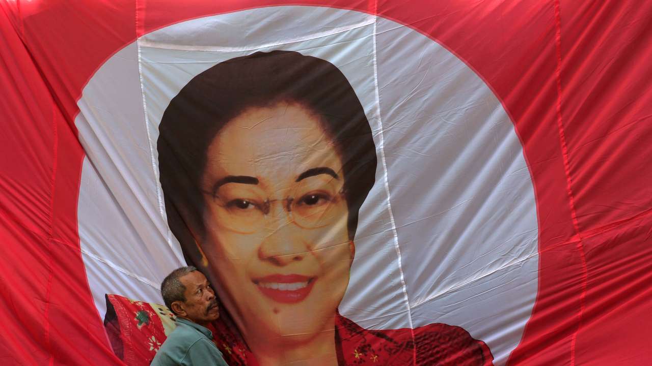 A man fixes a banner of Indonesia's former President Megawati Sukarnoputri in Jakarta