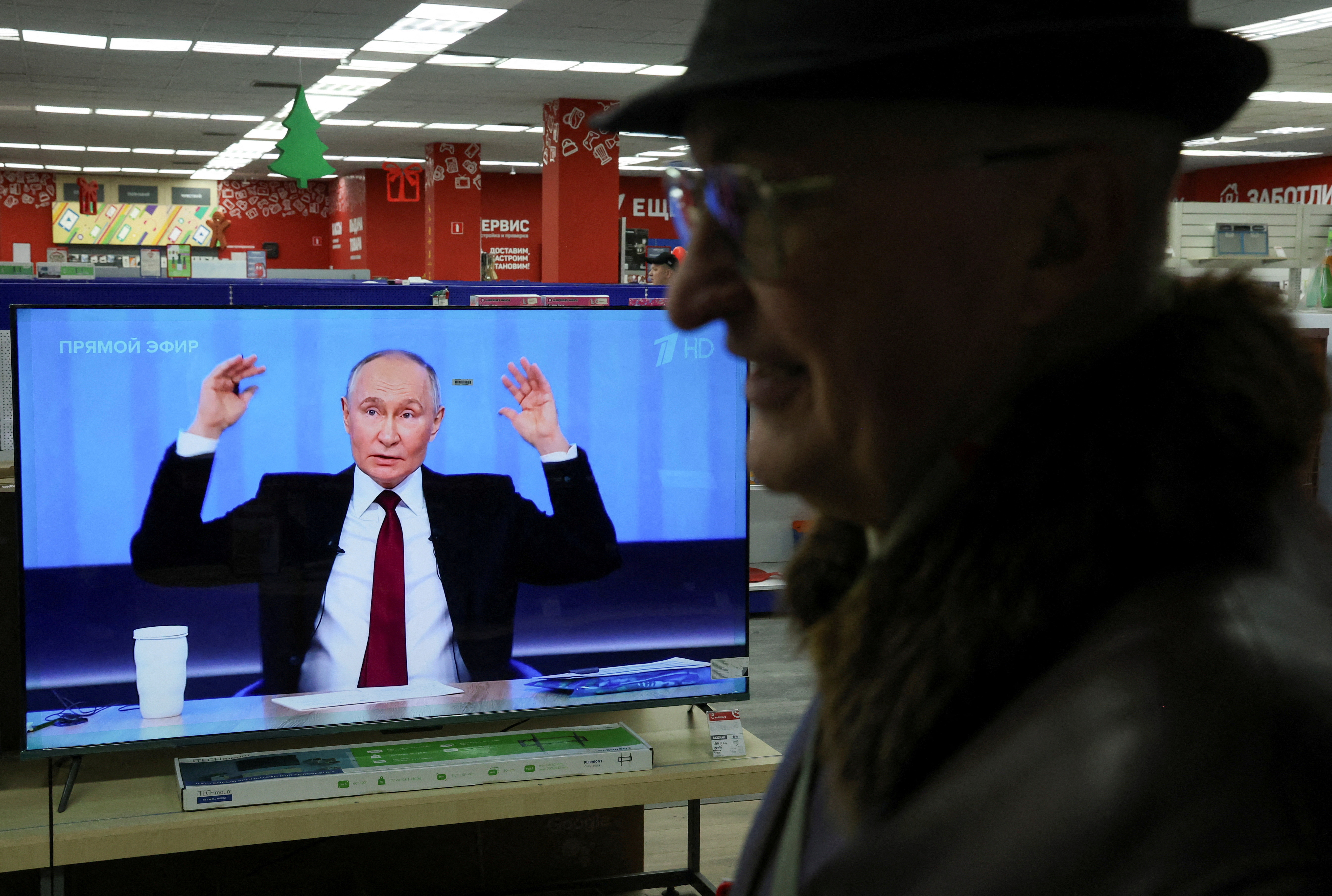 People watch Russian President Putin's annual press conference in Simferopol