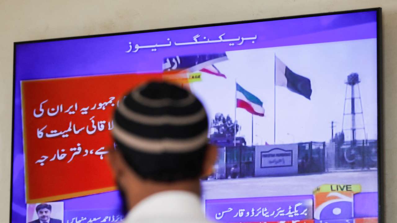 Man looks on television screen, after the Pakistani foreign ministry said the country conducted strikes targeting separatist militants inside Iran, in Karachi