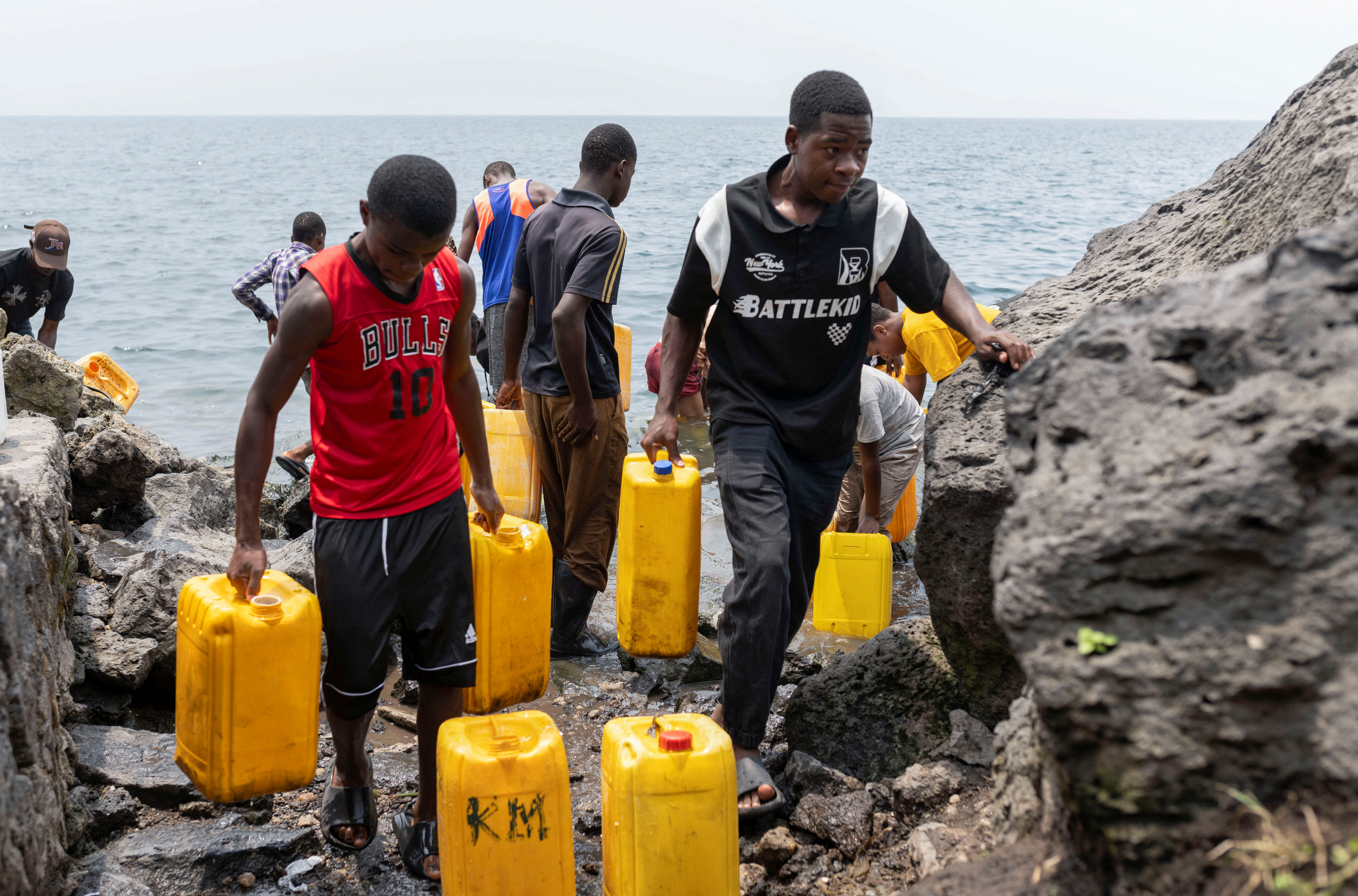 Civilians draw water from Lake Kivu after the town was taken by M23 rebels, in Goma,