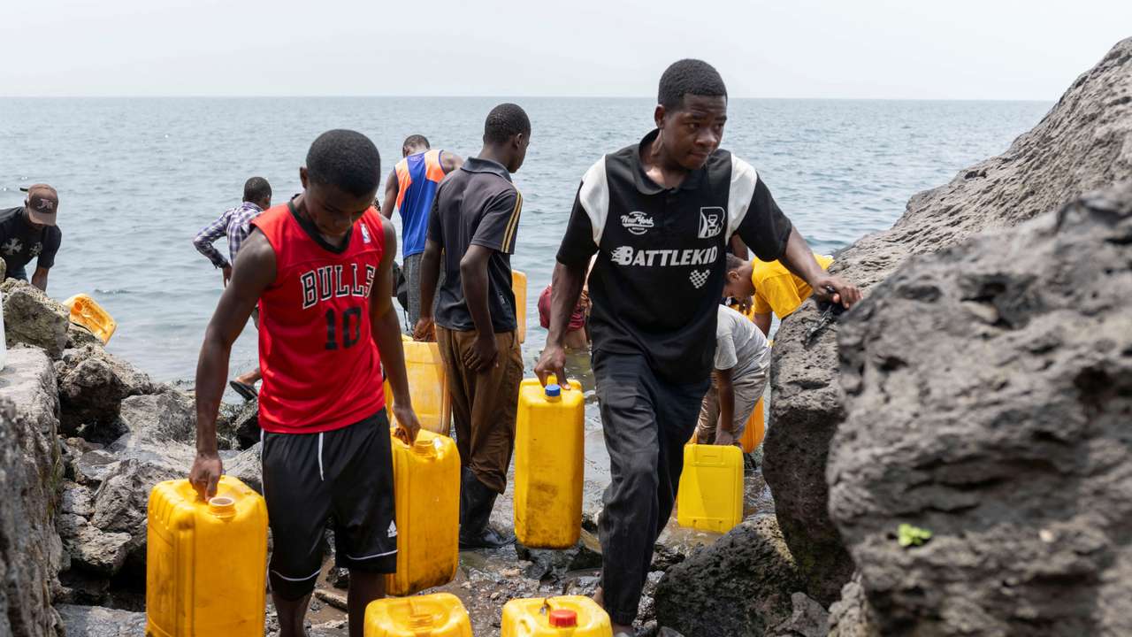 Civilians draw water from Lake Kivu after the town was taken by M23 rebels, in Goma,