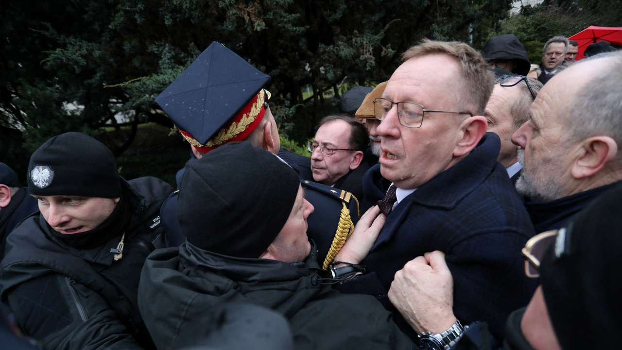 Former Interior Minister Kaminski surrounded by PiS politicians, is blocked by Marshal guard officers outside the parliament building in Warsaw