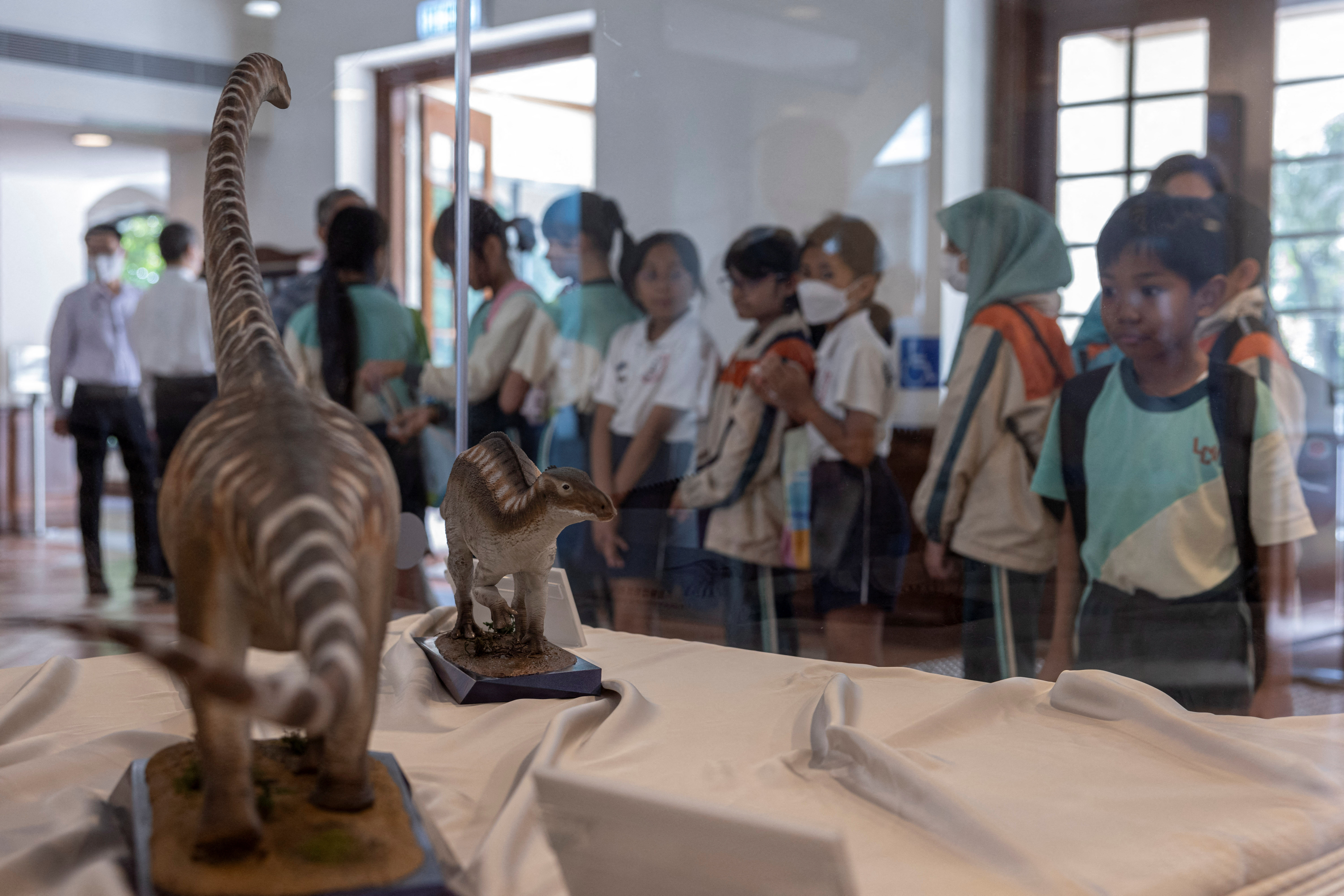 Dinosaur figurines are displayed at the Hong Kong Heritage Discovery Centre during an exhibition featuring a rock containing dinosaur bone fossils discovered for the first time, in Hong Kong