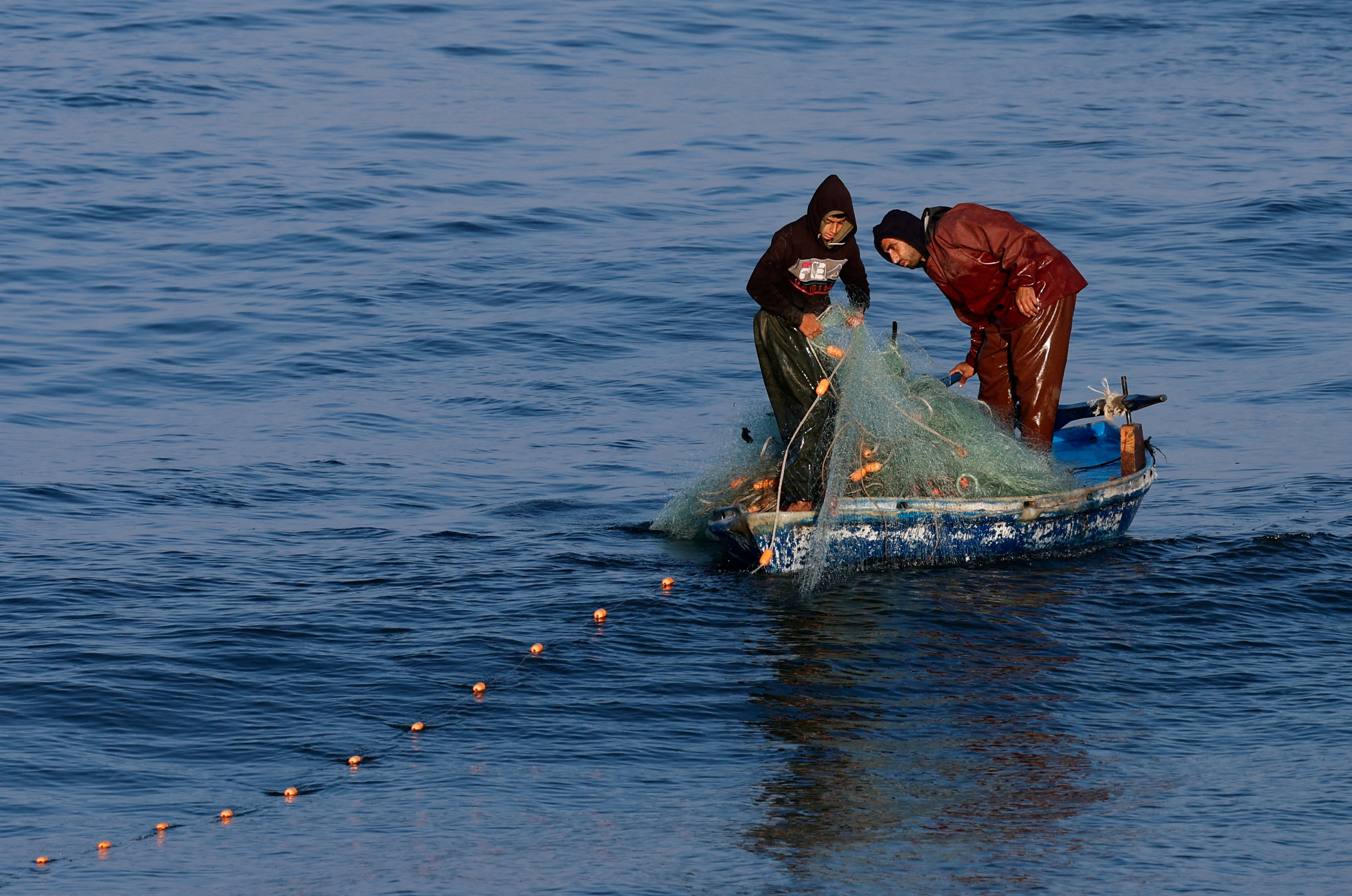 Palestinian fishermen work in Rafah