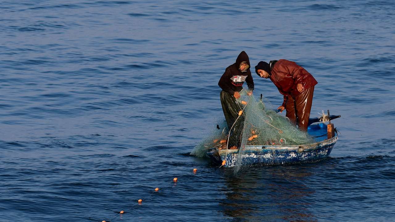 Palestinian fishermen work in Rafah