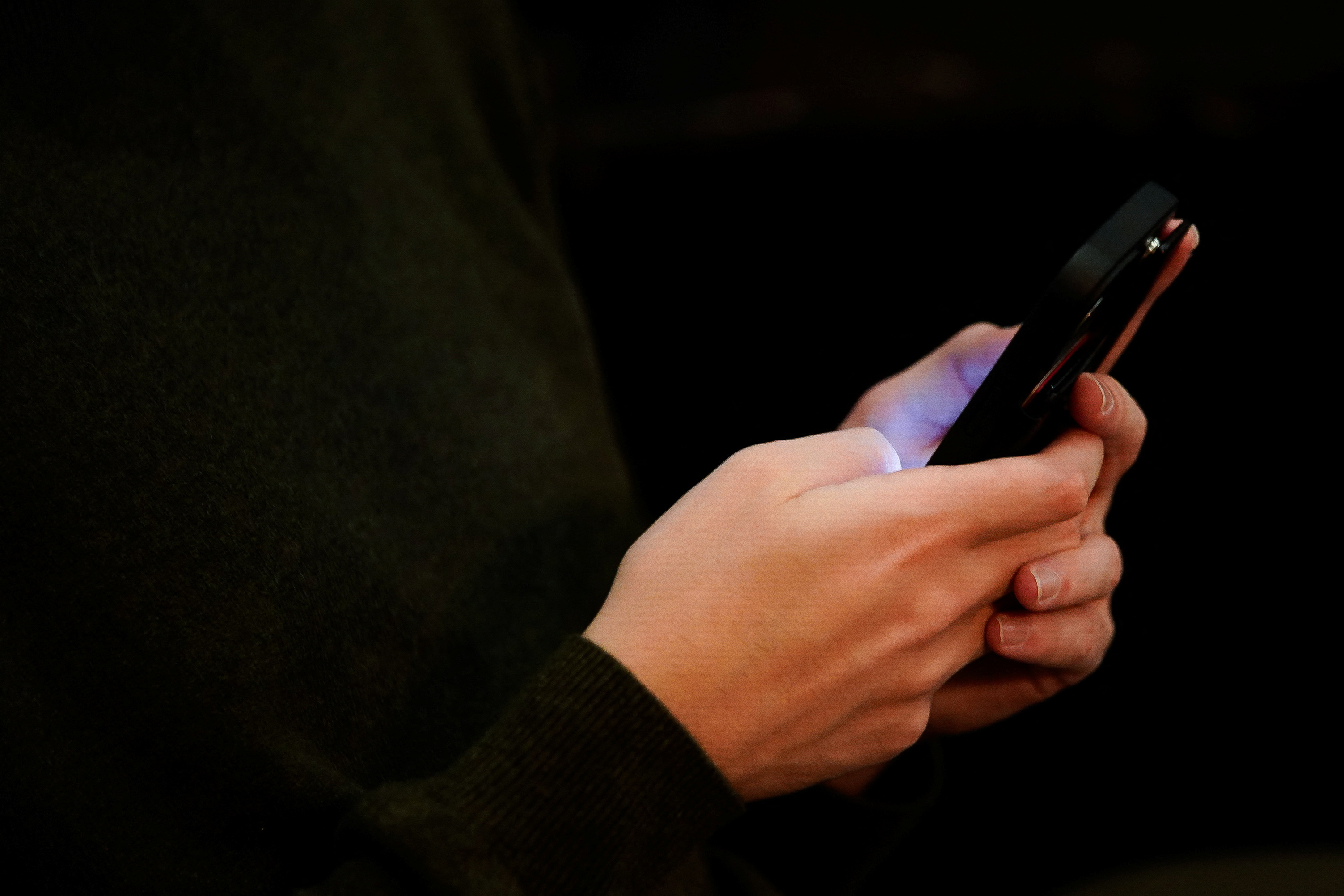 Josh Joffe, a 23-year-old Jewish American, sits with the phone he uses to access social media in Washington