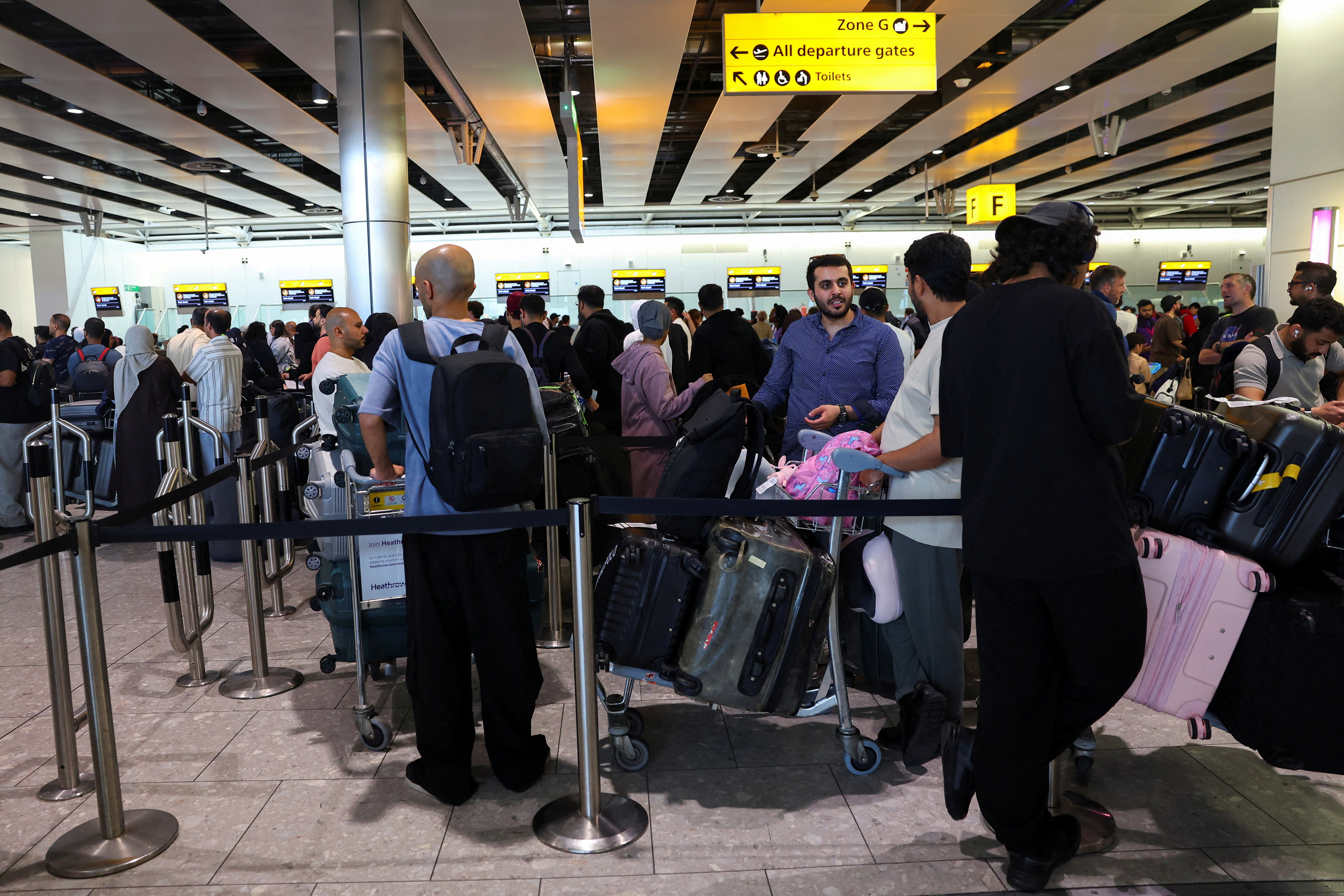 FILE PHOTO: Travellers at Heathrow Airport amid cyberattack disruptions, in Greater London