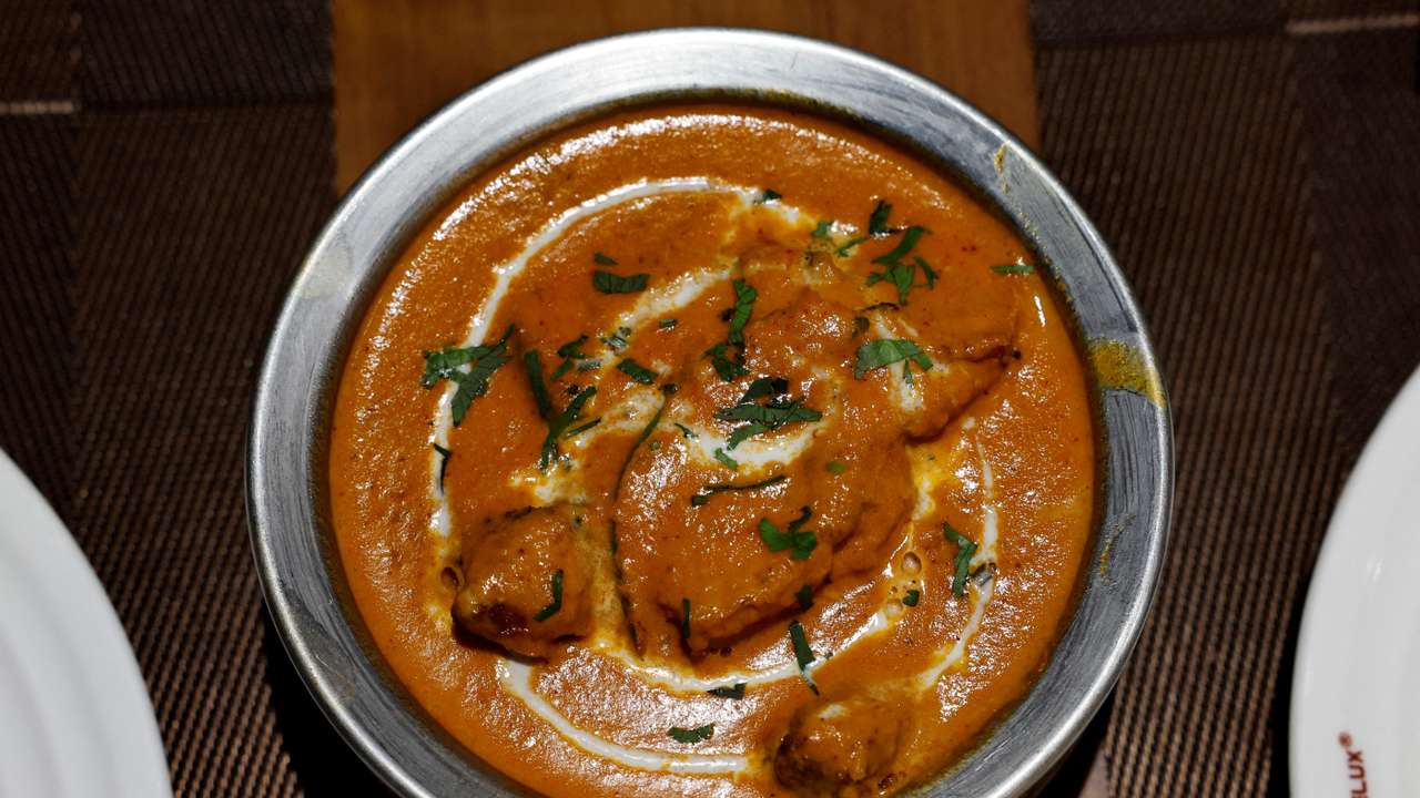A freshly prepared butter chicken dish is placed on a table inside the Moti Mahal Delux restaurant in New Delhi