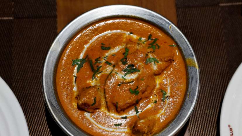 A freshly prepared butter chicken dish is placed on a table inside the Moti Mahal Delux restaurant in New Delhi