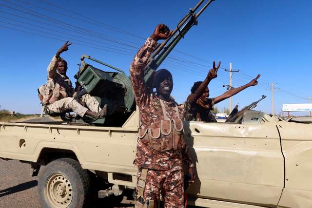 Sudan's army soldiers celebrate after entering Wad Madani