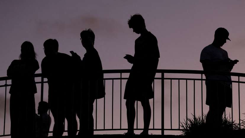 People use their mobile phones at dusk in Brisbane