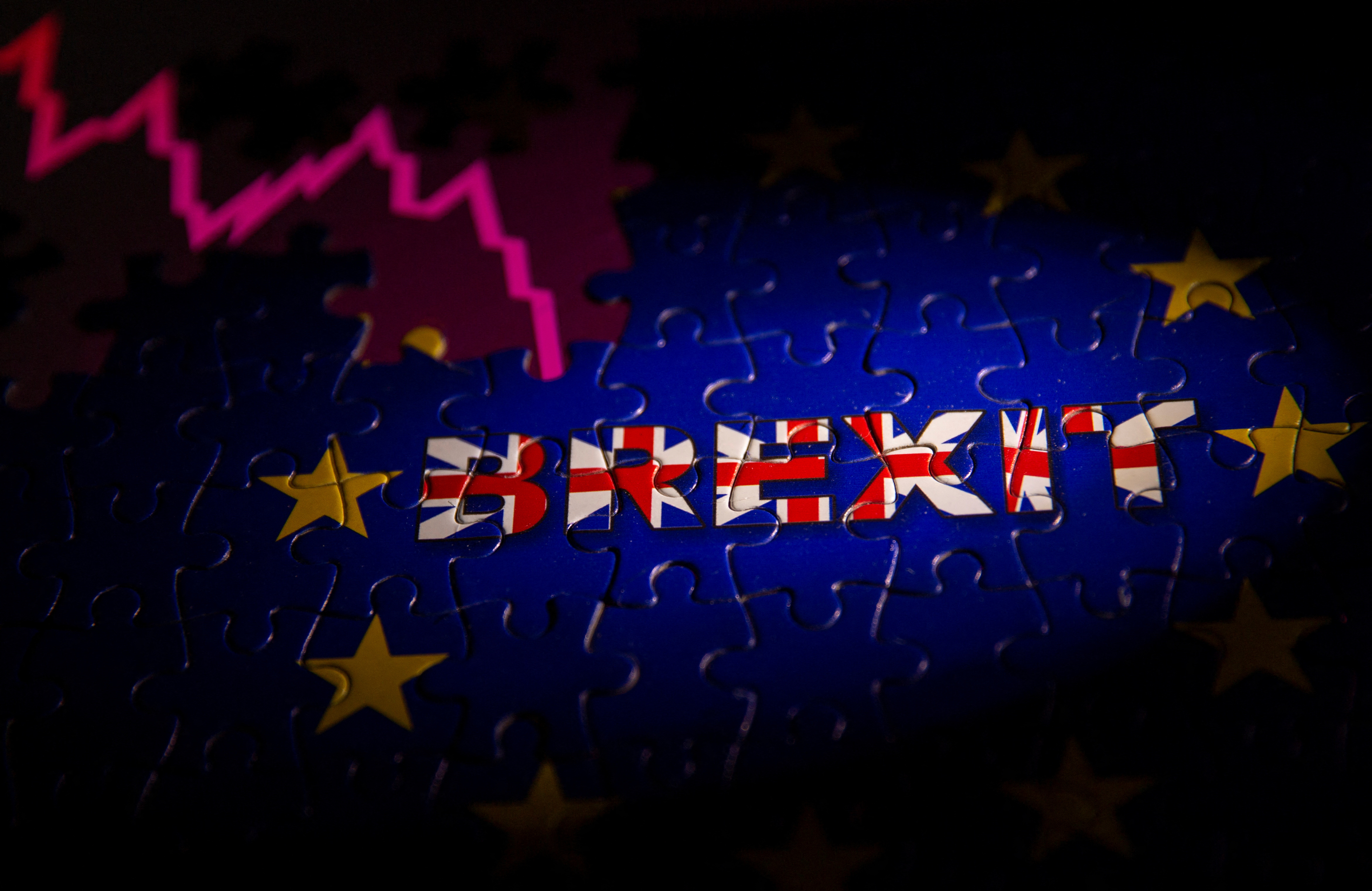 Puzzle with printed EU flag and BREXIT words is placed on displayed stock graph in this illustration taken