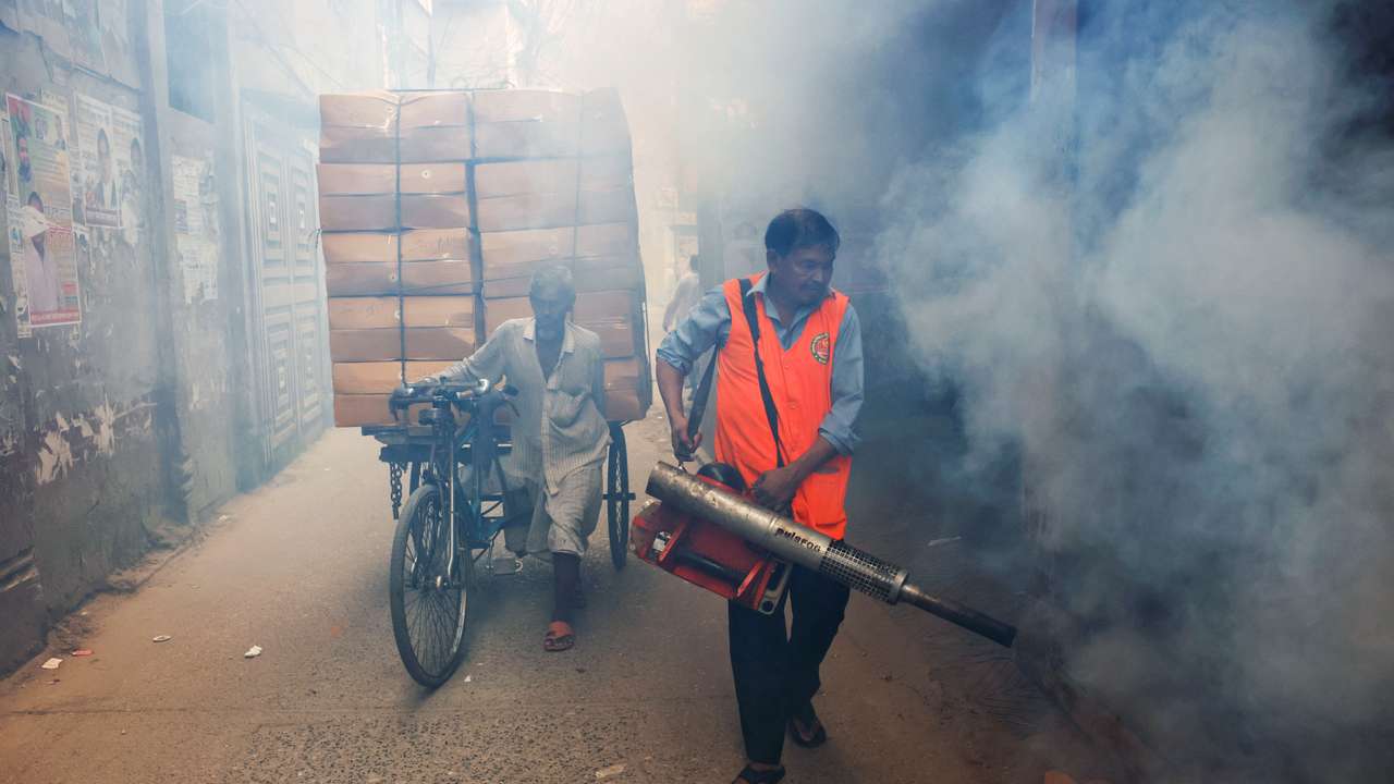 A city corporation worker sprays fumigator to control mosquitoes, as number of dengue infected patients increase, in Dhaka
