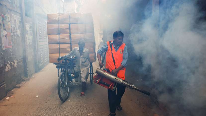 A city corporation worker sprays fumigator to control mosquitoes, as number of dengue infected patients increase, in Dhaka