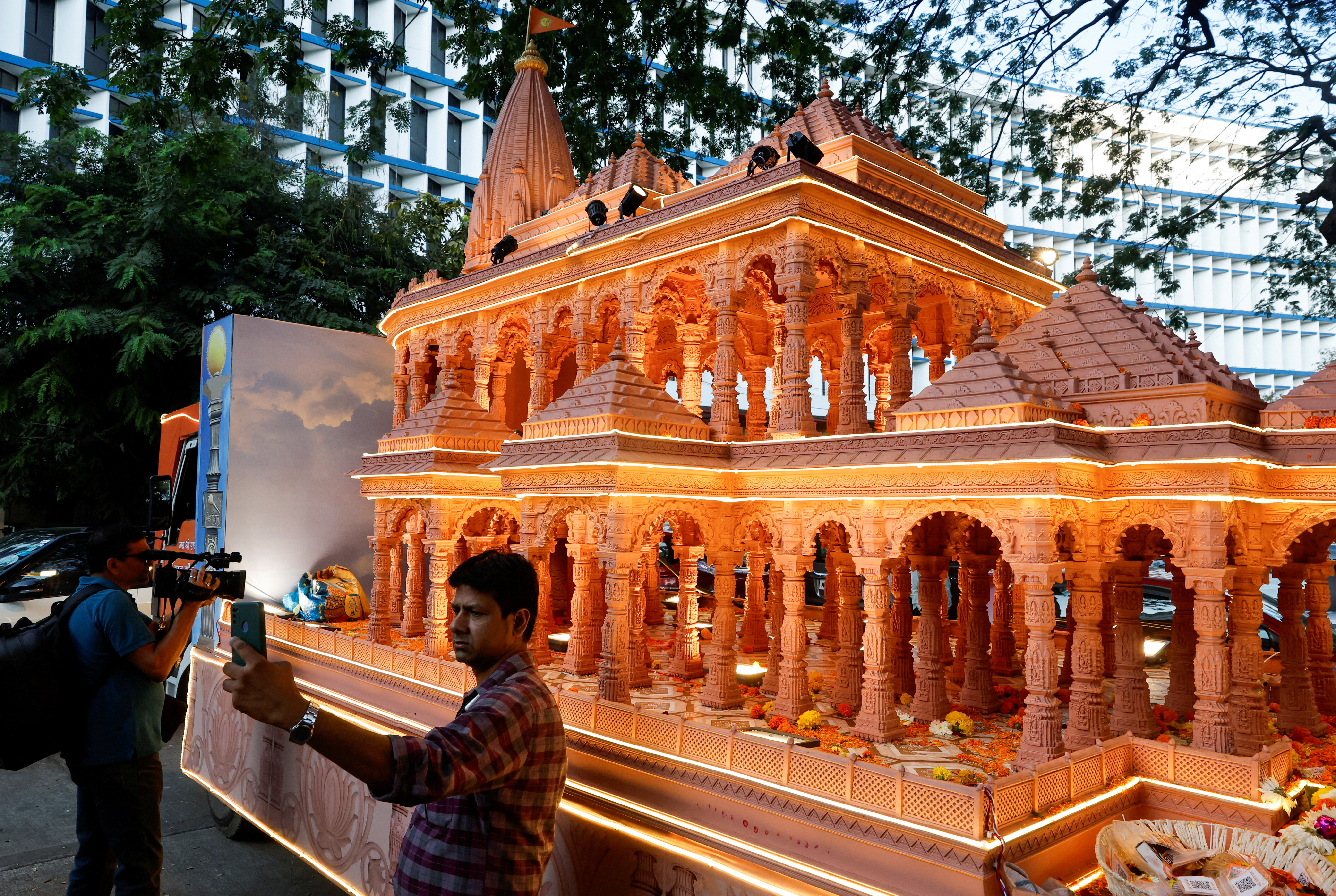 FILE PHOTO: FILE PHOTO: A man takes a selfie with a replica of the Ram Mandir outside the BJP headquarters in Mumbai