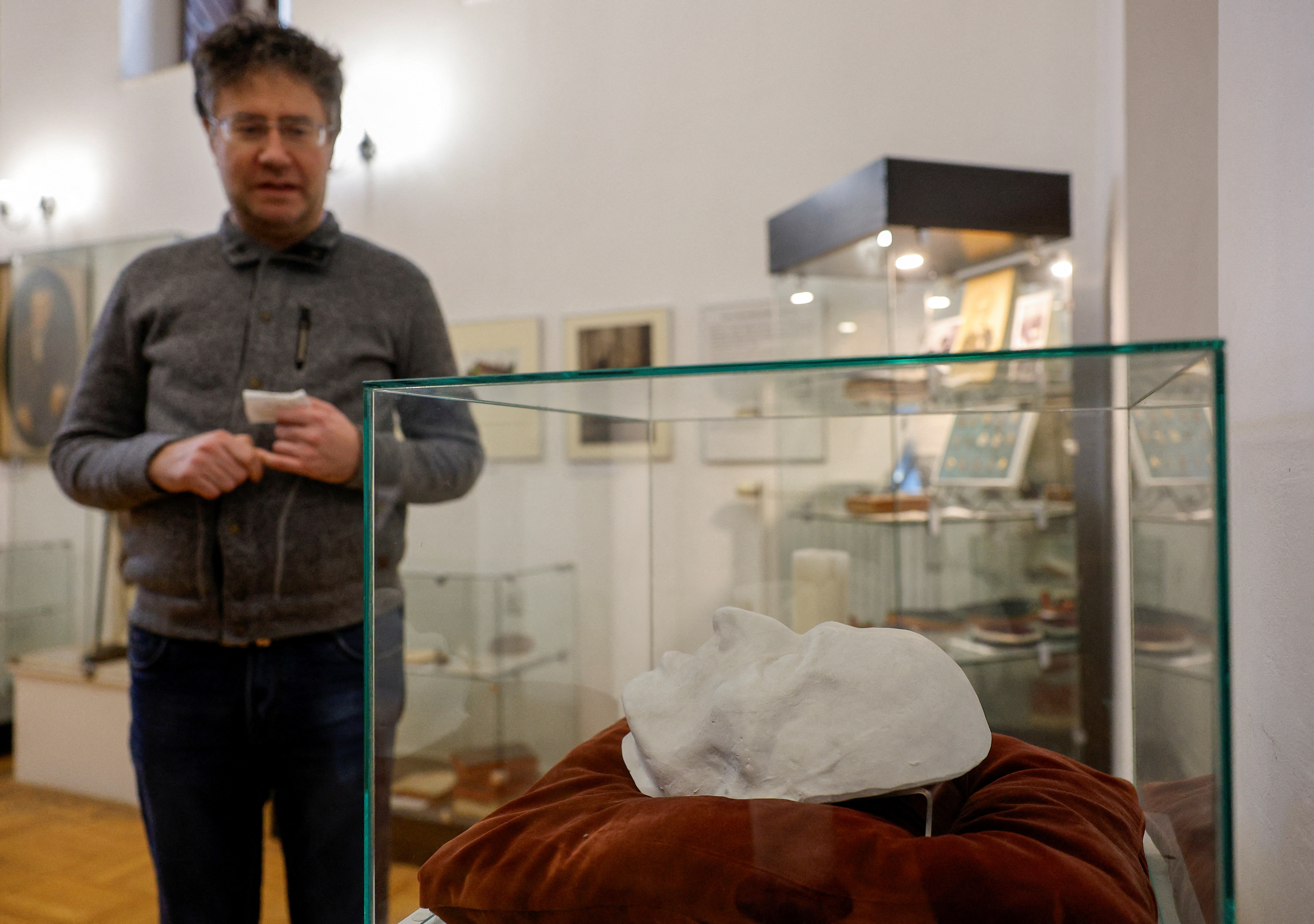 A visitor stands next to a copy of German philosopher Immanuel Kant's death mask exhibited in the museum in Kaliningrad