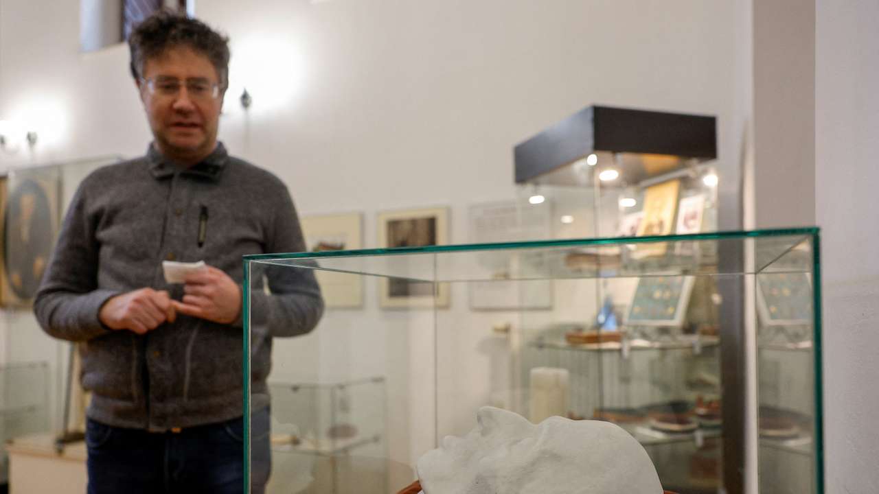 A visitor stands next to a copy of German philosopher Immanuel Kant's death mask exhibited in the museum in Kaliningrad