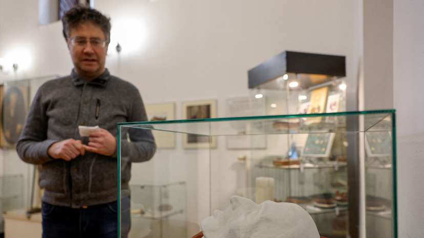 A visitor stands next to a copy of German philosopher Immanuel Kant's death mask exhibited in the museum in Kaliningrad