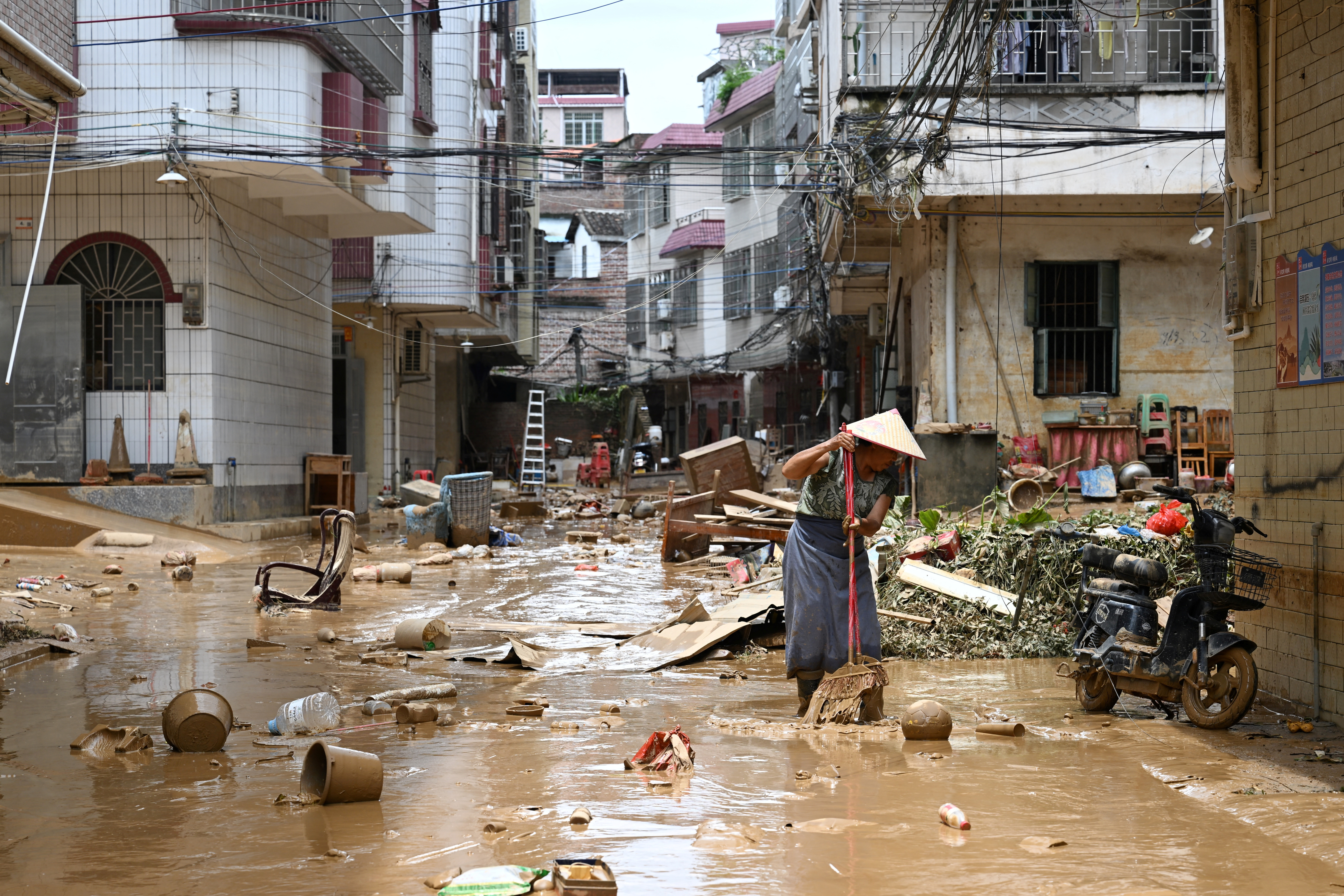 Resident cleans up a street after heavy rainfall led to flooding in Zhaoqing