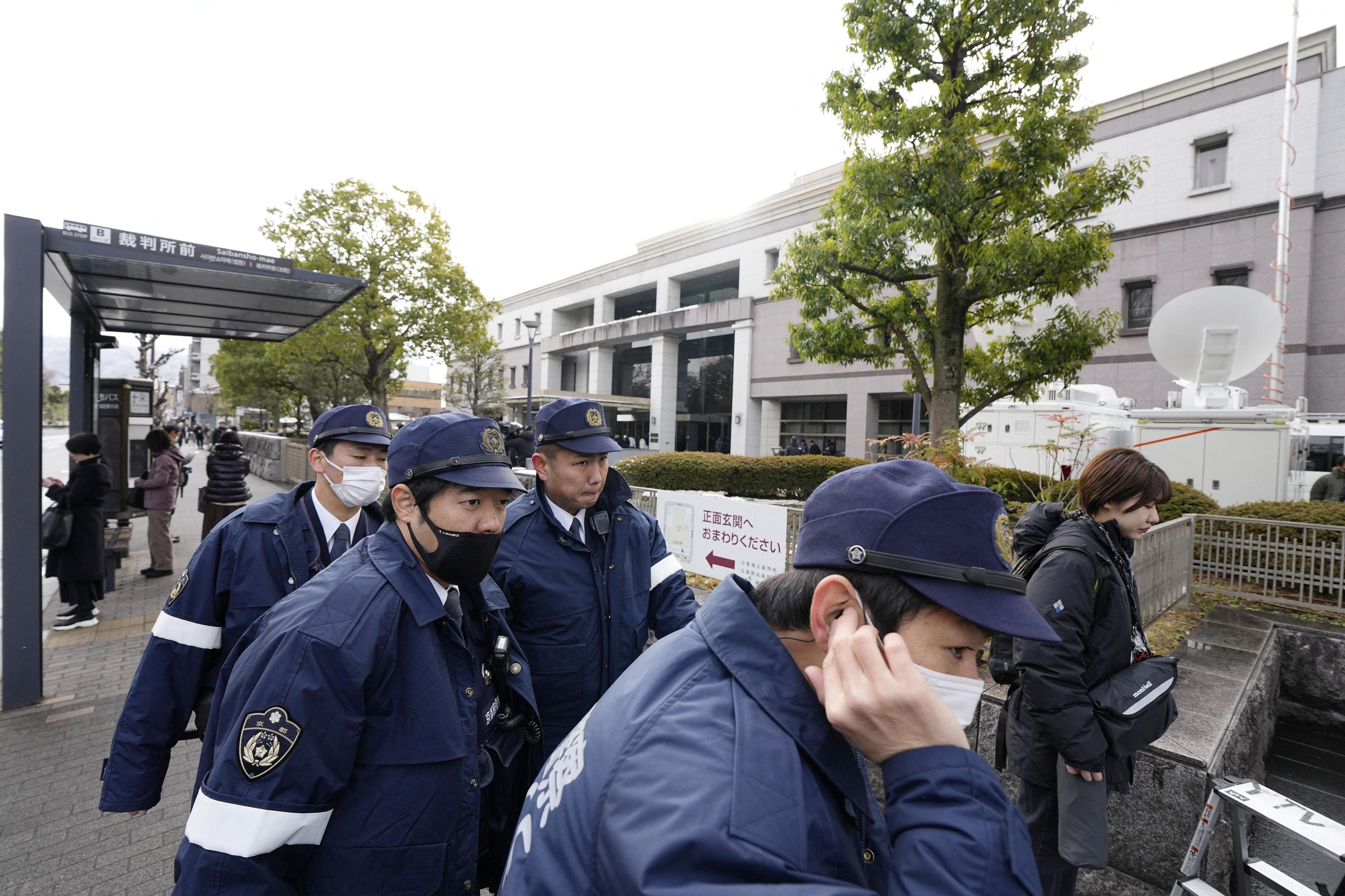 Police officers gather outside the Kyoto District Court ahead of the sentencing hearing for Shinji Aoba, who has confessed to a deadly arson attack in July 2019 on a Kyoto Animation Co. studio in Kyoto