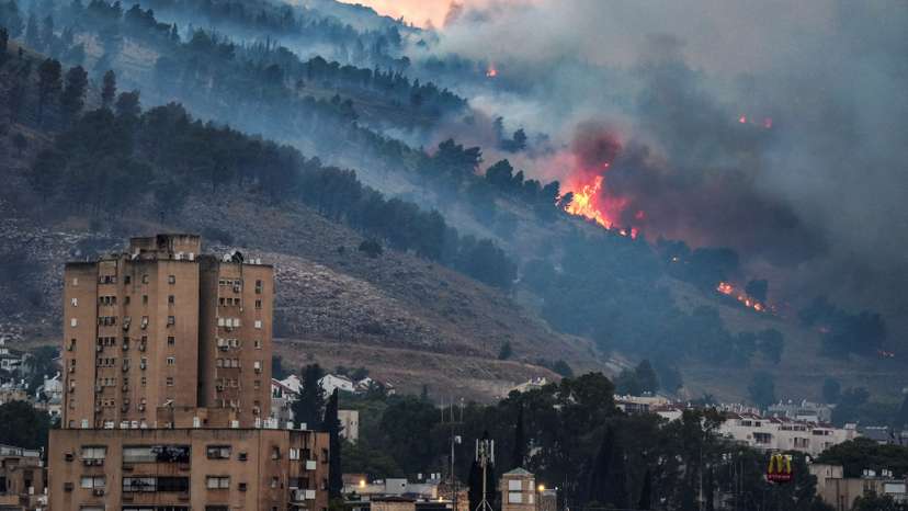 Smoke and fire covers the area following rocket attacks from Lebanon near Kiryat Shmona