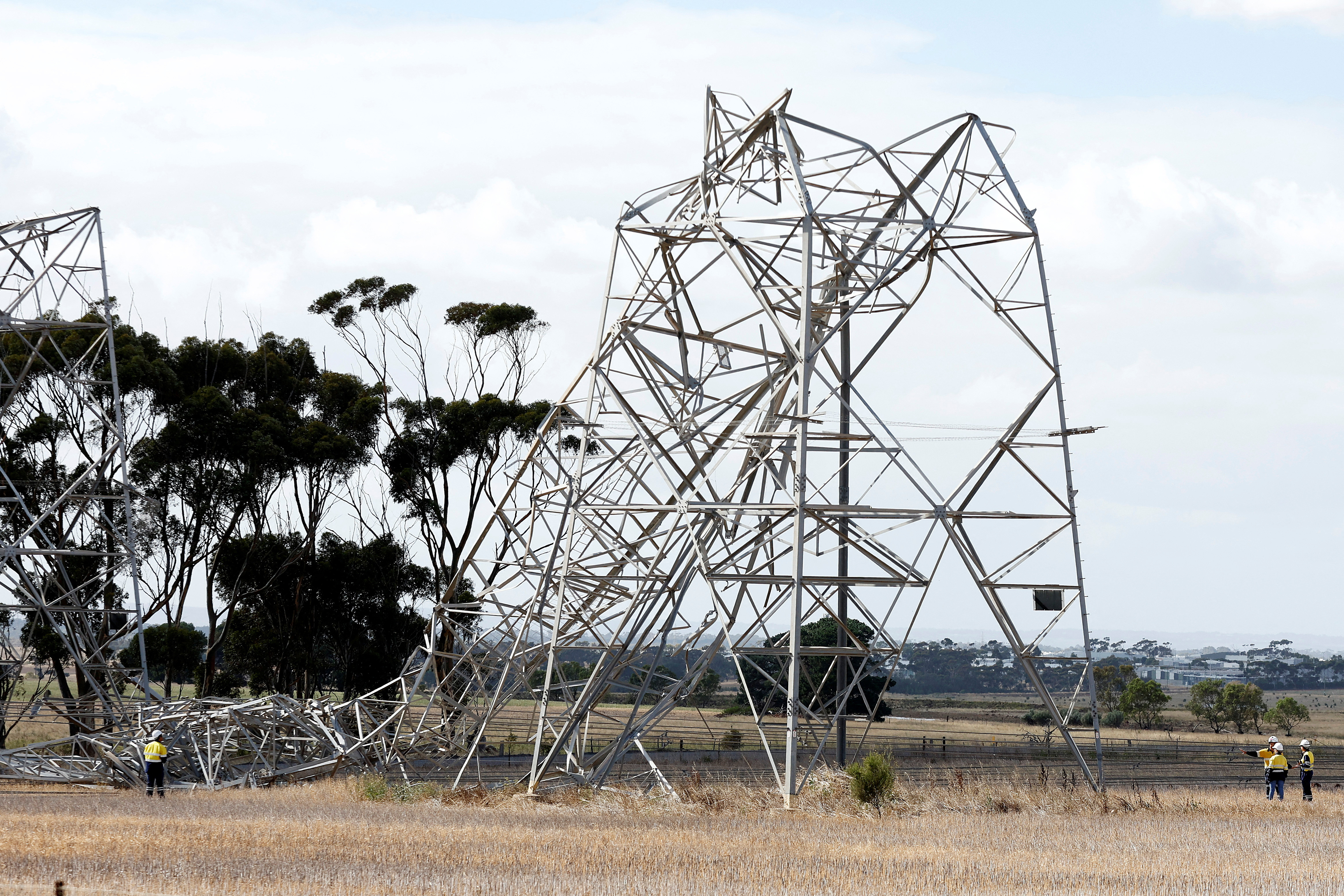 Workers inspect damaged transmission towers at Anakie